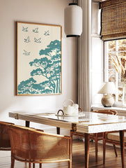 Teal stylised birds flying above pine trees in an illustrative, textured Japanese art print, in a styled room mockup