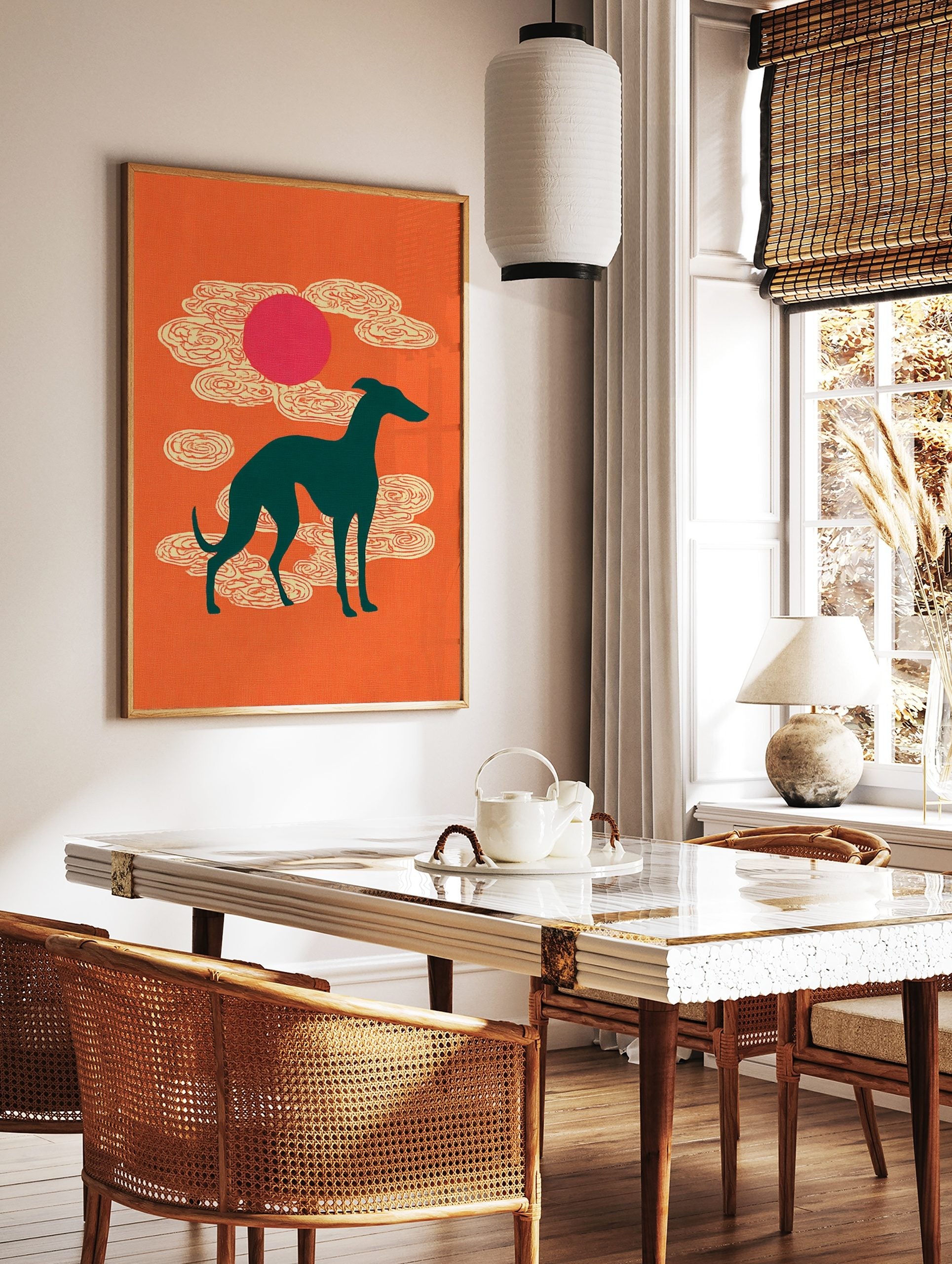 Teal greyhound silhouette against an orange background with a pink sun and stylised white clouds, in a styled room mockup