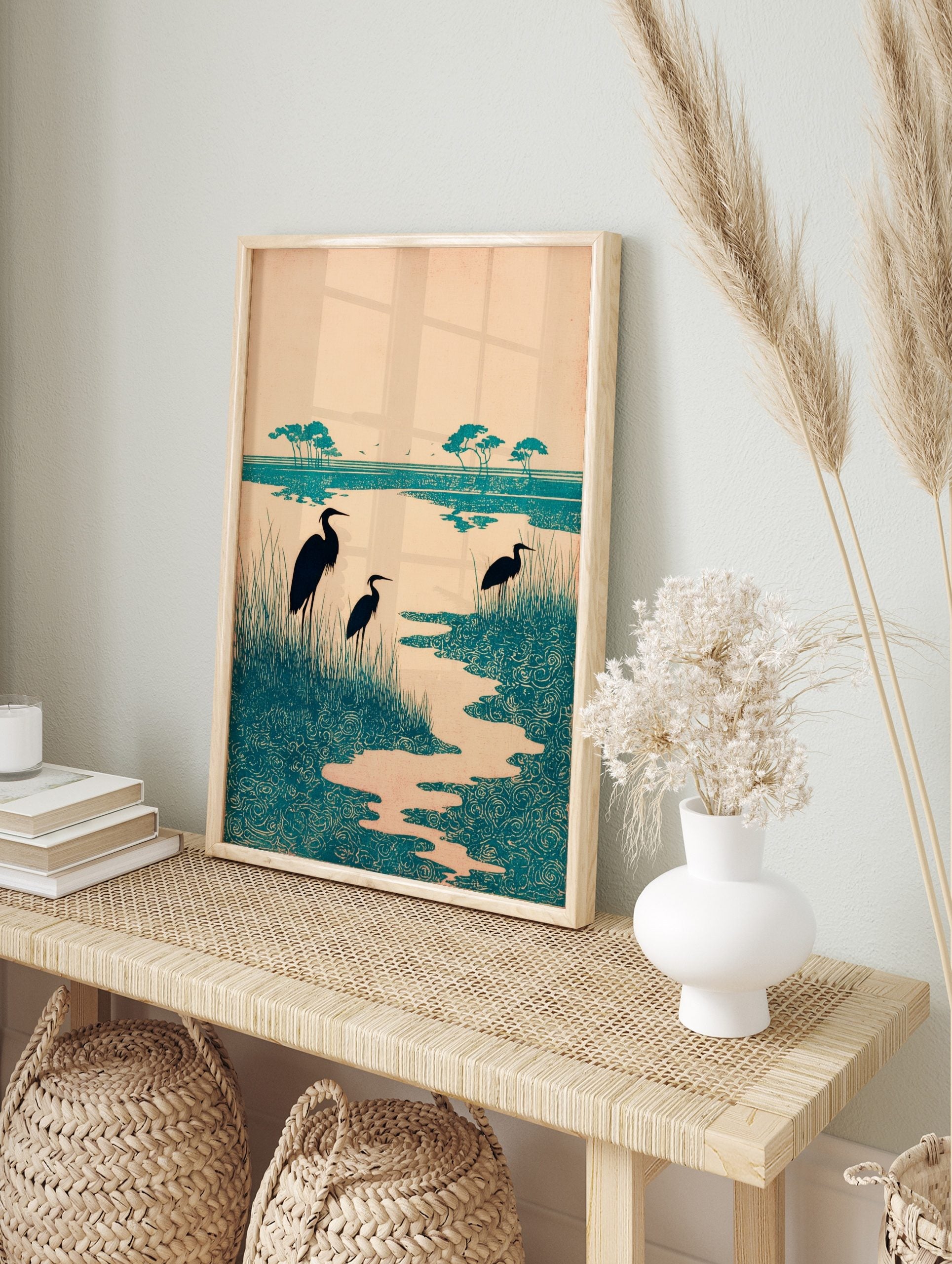 Teal heron wetland art print with three birds, tall grasses, and stylised swirling water, in an alternate framed mockup
