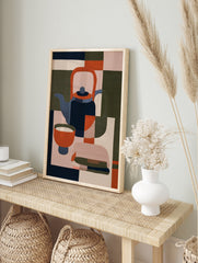 Minimalist geometric illustration of a teapot and bowl in navy, orange, and olive green on a, in an alternate framed mockup