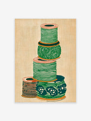 Illustrated green and orange thread spool wall art stacked on a textured beige background.