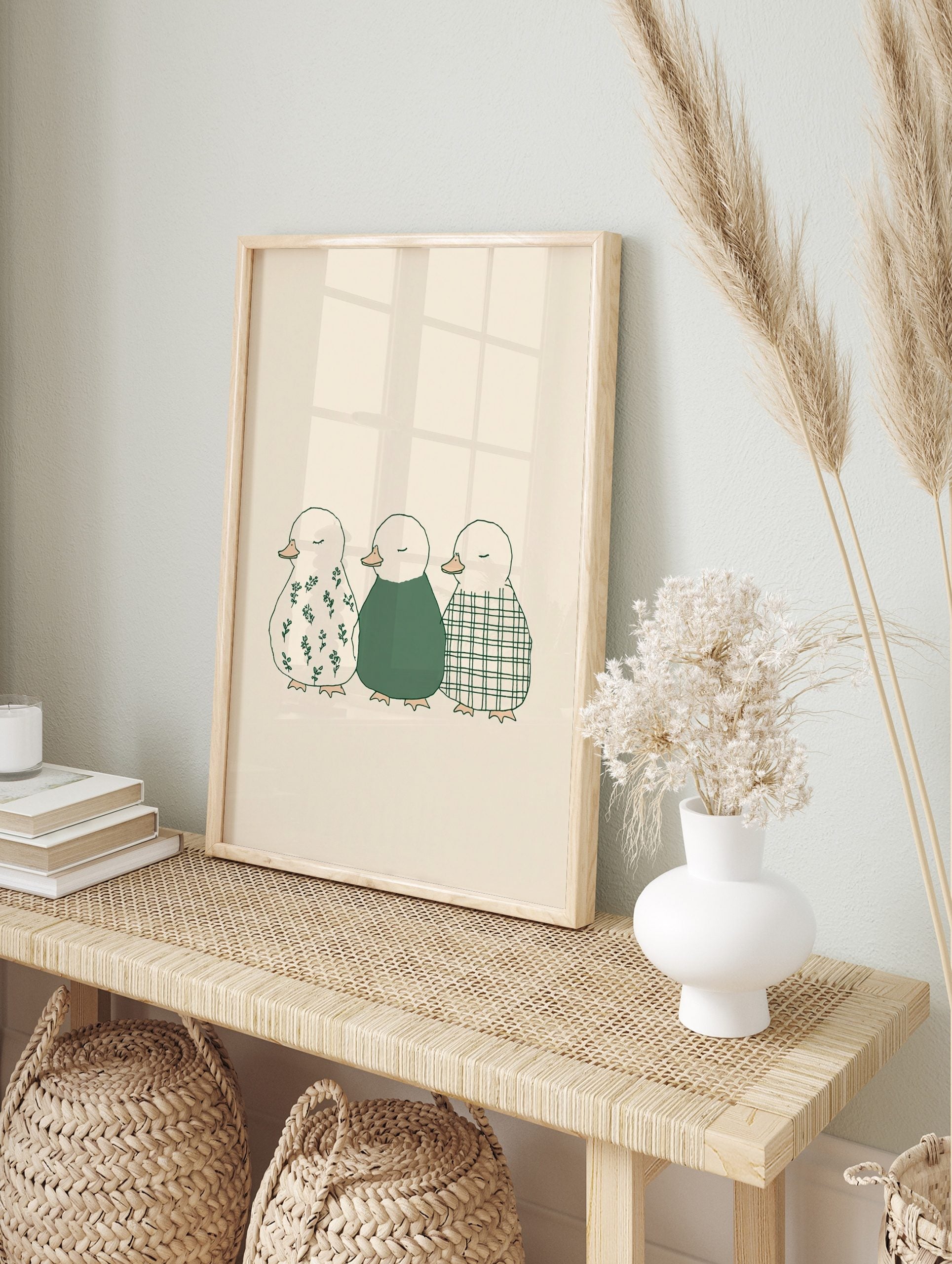 Illustration of three ducklings in a row, with floral, solid green, and plaid patterns on a, in an alternate framed mockup