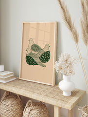 Illustrative print of three green doves with patterned feathers on a beige background, in an alternate framed mockup
