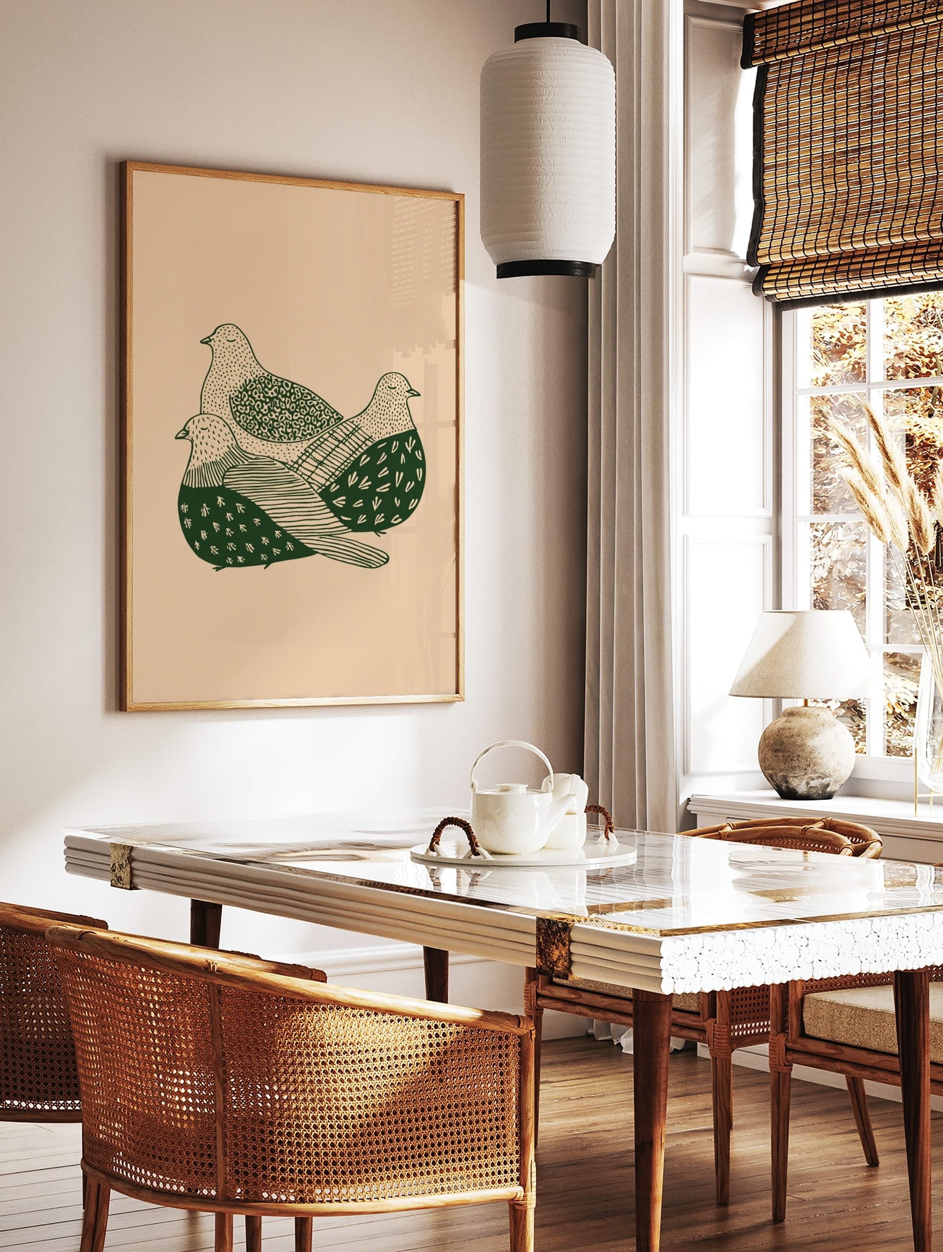 Illustrative print of three green doves with patterned feathers on a beige background, huddled, in a styled room mockup