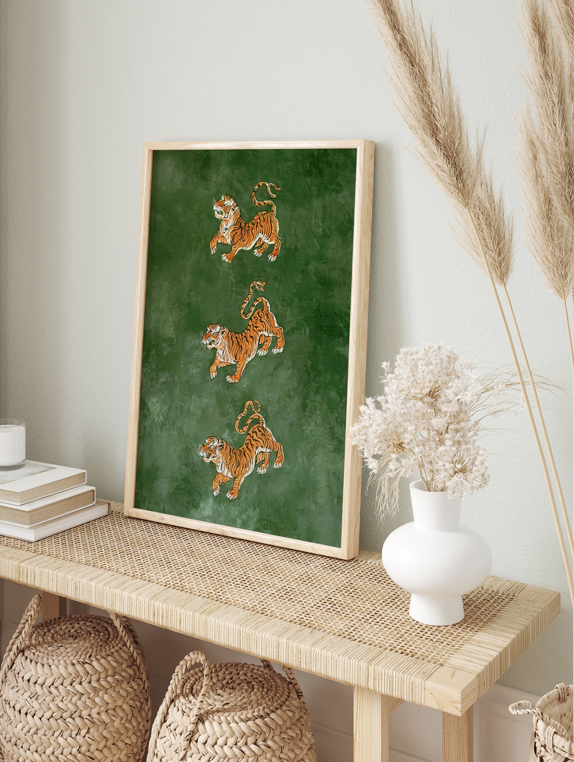 Three tigers in leaping poses on a deep green background, illustrative wildlife art print, in an alternate framed mockup