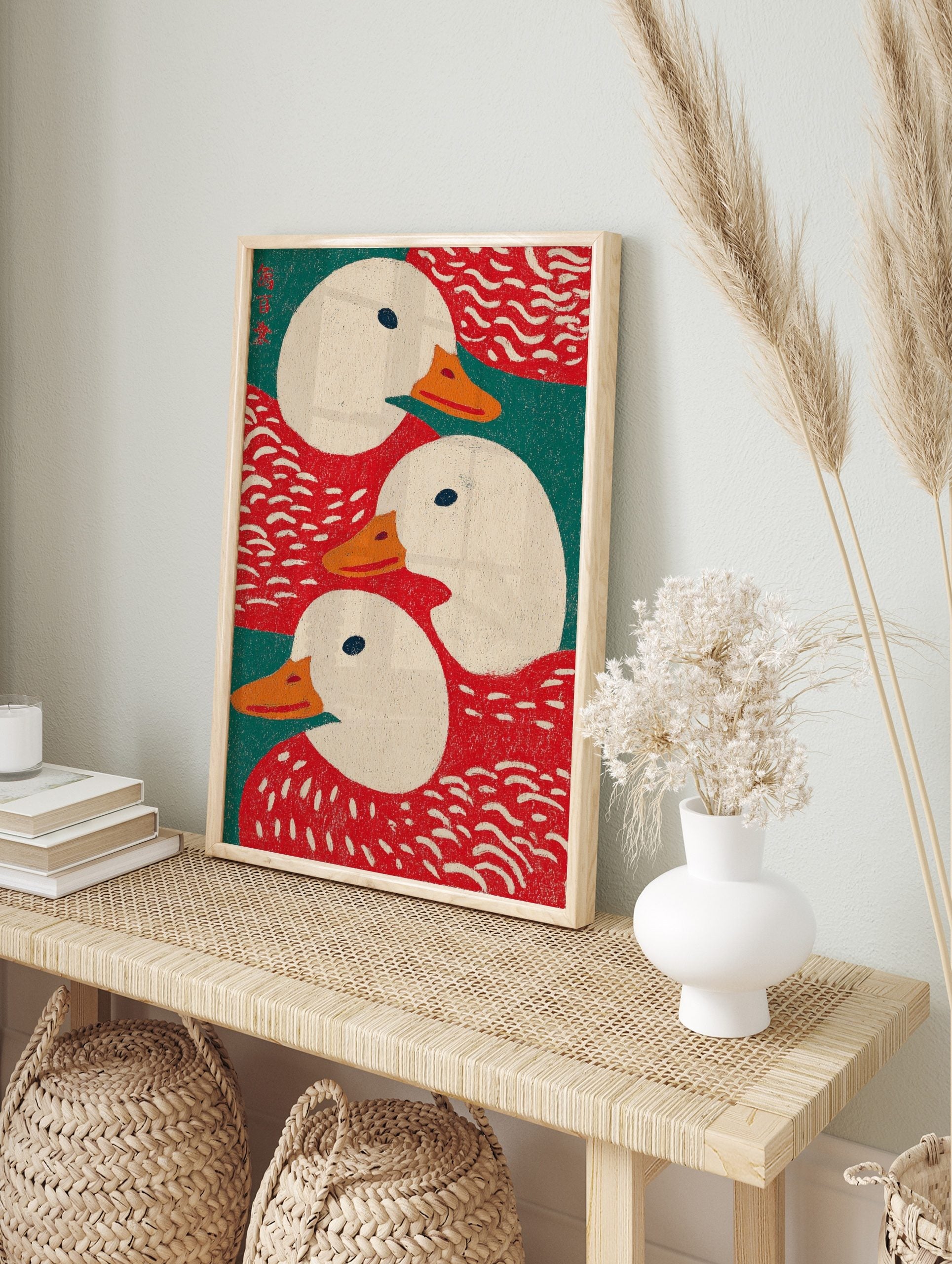 Illustrative art print showing three white ducks with orange beaks against red and teal green, in an alternate framed mockup