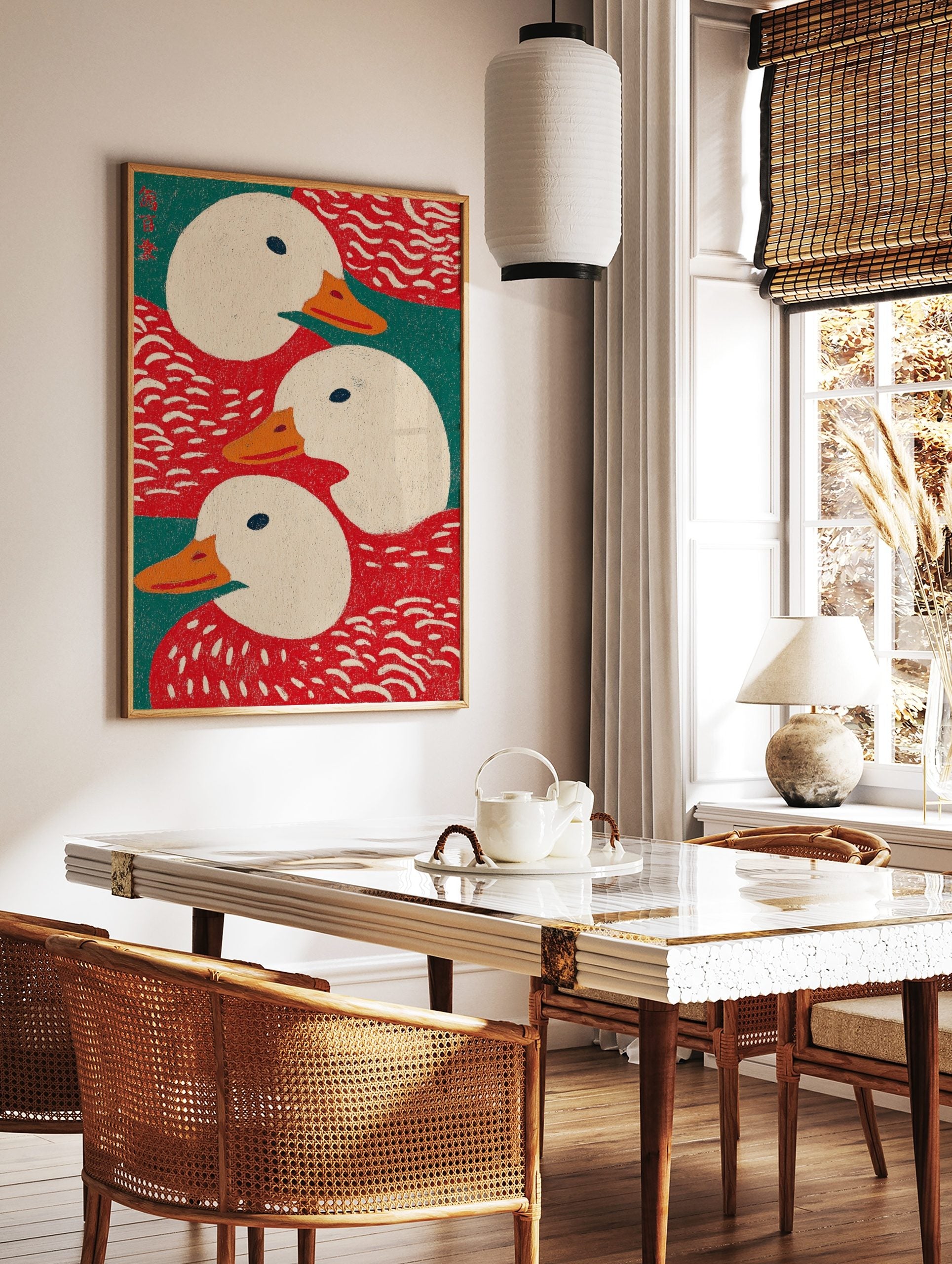 Illustrative art print showing three white ducks with orange beaks against red and teal green, in a styled room mockup