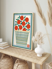 Illustrative print of red tomatoes with green leaves in a striped basket, framed by green and, in an alternate framed mockup