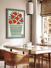 Illustrative print of red tomatoes with green leaves in a striped basket, framed by green and blue, in a styled room mockup