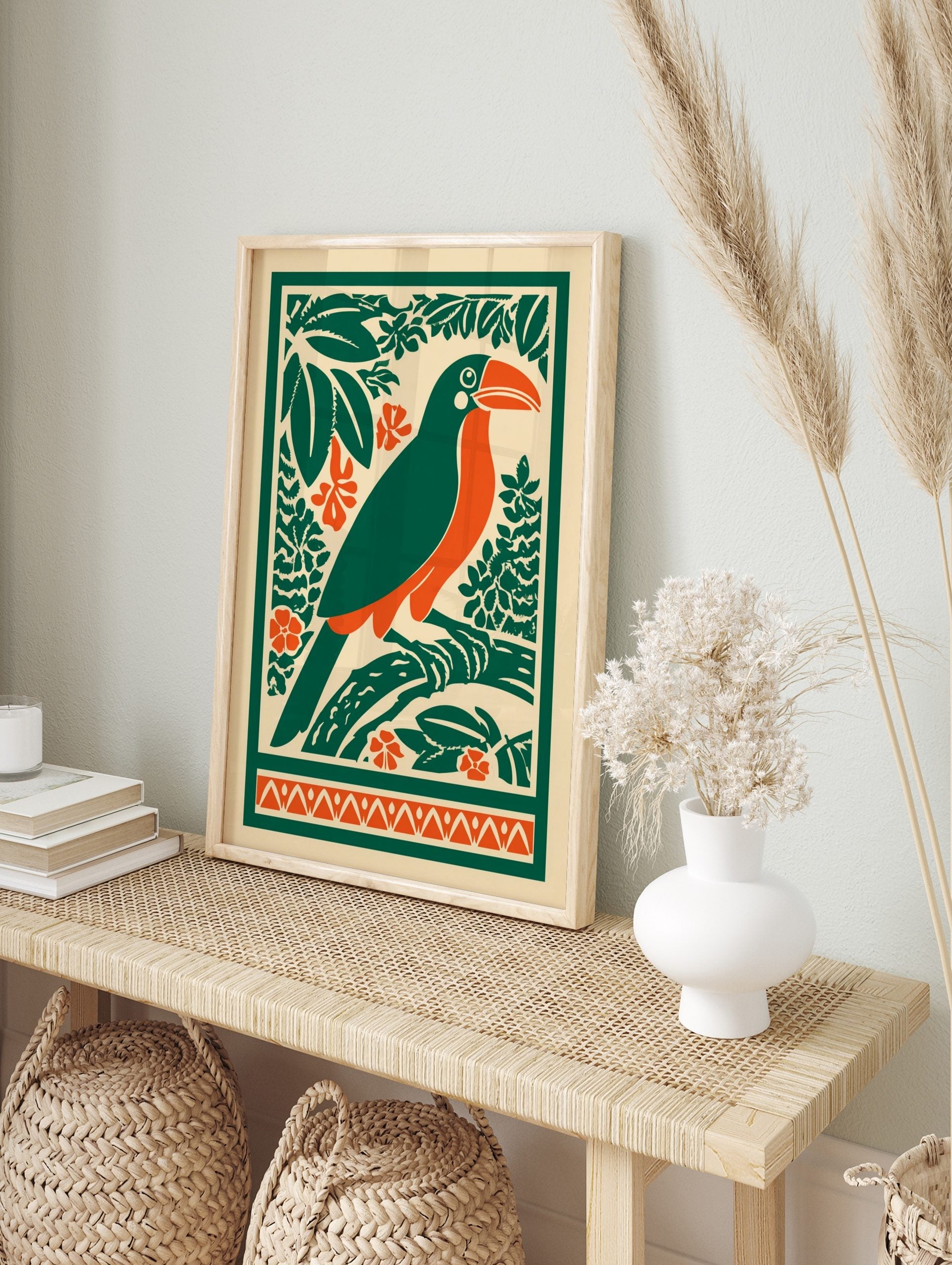 Illustrative toucan bird print with orange beak, green body, tropical leaves, and orange, in an alternate framed mockup