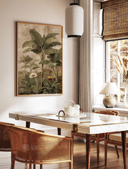 Tropical botanical painting with green banana leaves, palm trees, white daisies, and yellow flower, in a styled room mockup