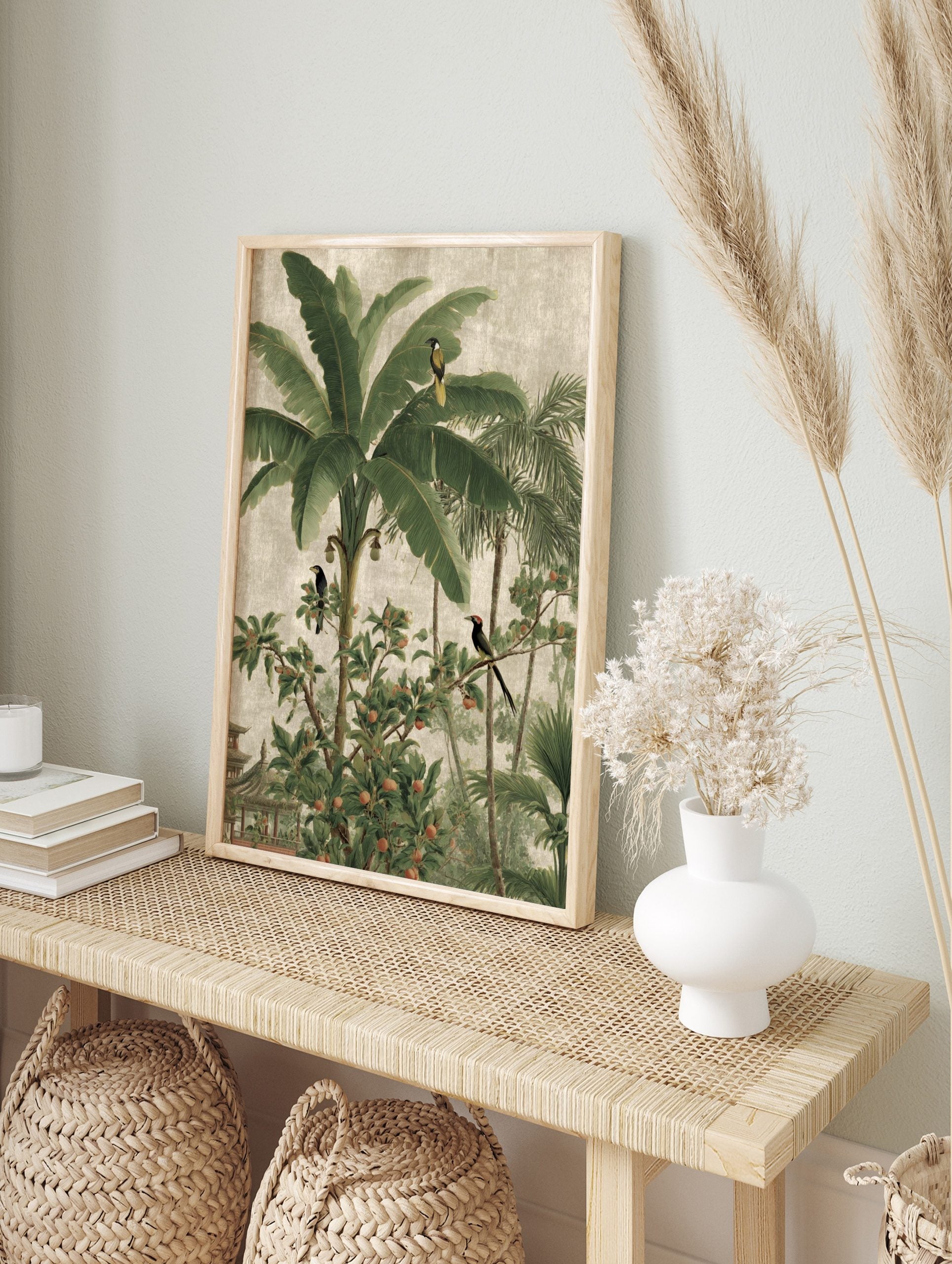 Tropical jungle landscape wall art with banana trees, palm fronds, exotic birds, and a pagoda, in an alternate framed mockup