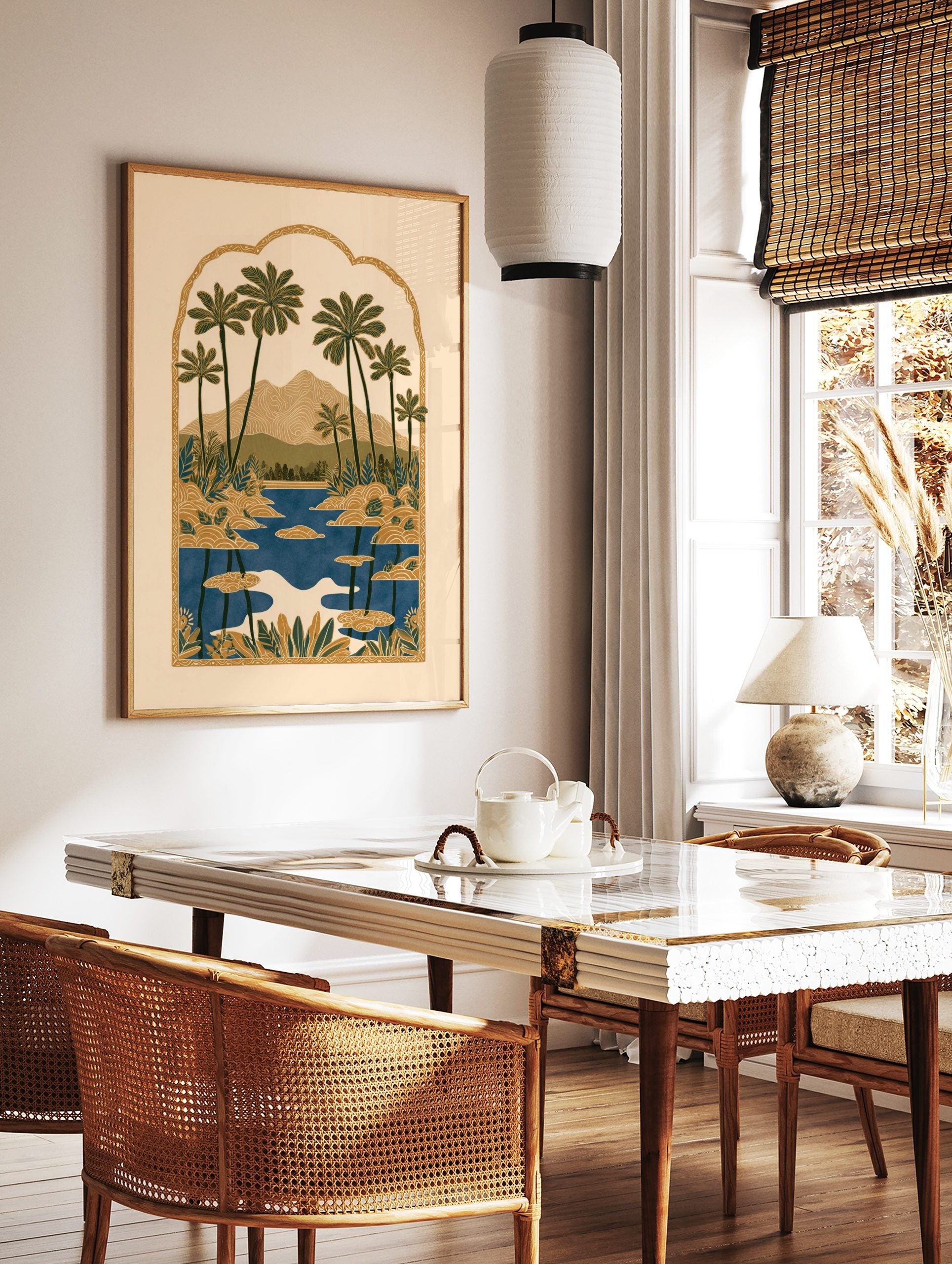 Illustrative tropical landscape print with palm trees, mountains, and a lake inside an ornate, in a styled room mockup
