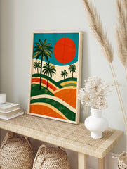 Illustrative landscape art print with green palm trees, large red sun, and layered orange and, in an alternate framed mockup