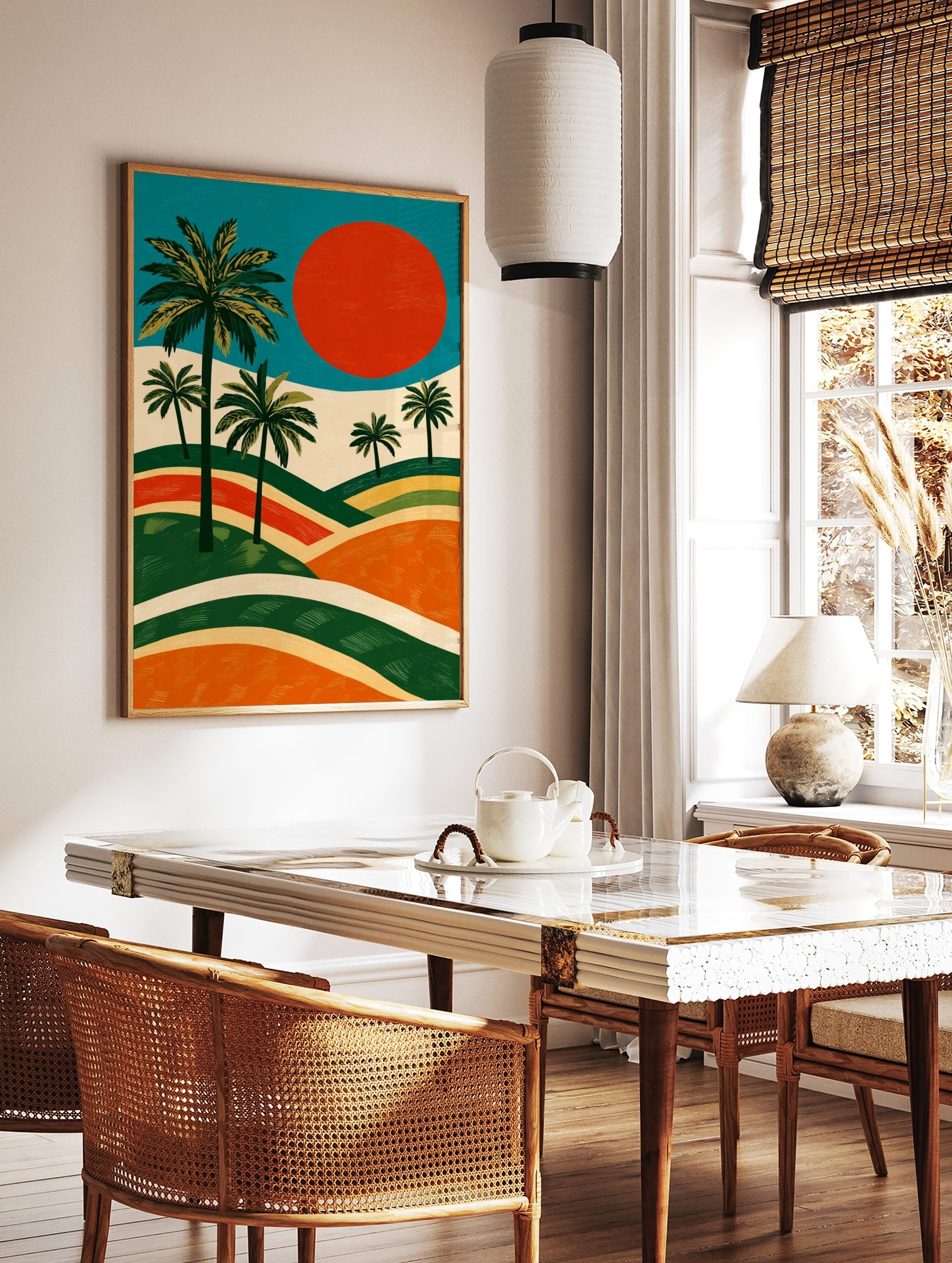 Illustrative landscape art print with green palm trees, large red sun, and layered orange and green, in a styled room mockup