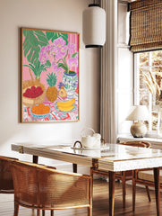 Tropical still life illustration with pink orchids, green leaves, lychees, pineapple, oranges, and, in a styled room mockup