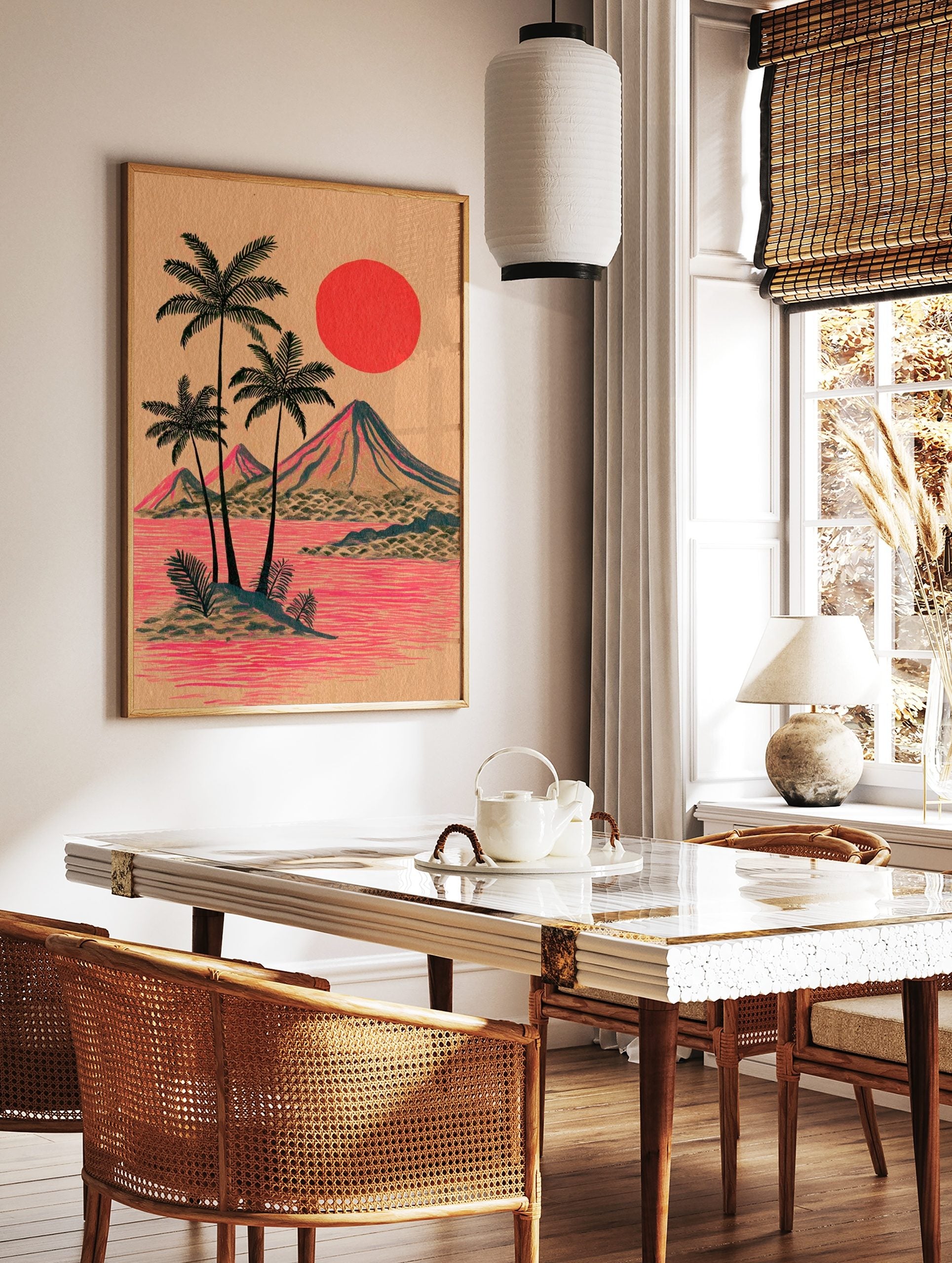 Illustrative tropical island print with palm trees, mountains, red sun, and pink water on tan paper, in a styled room mockup