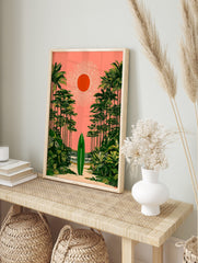 Green surfboard on sandy path, framed by palm trees under coral pink sky with orange sun, in an alternate framed mockup