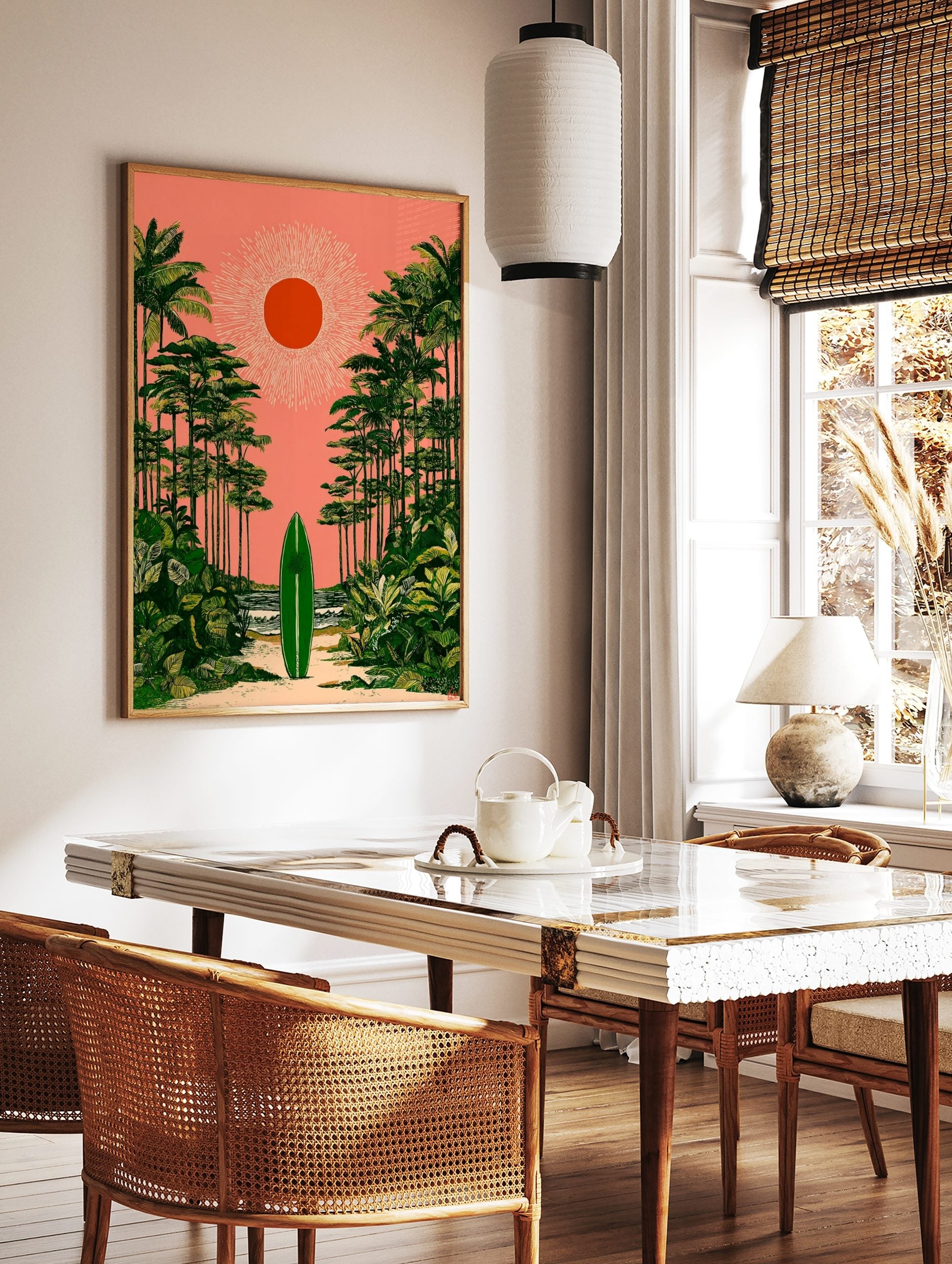 Green surfboard on sandy path, framed by palm trees under coral pink sky with orange sun, tropical, in a styled room mockup