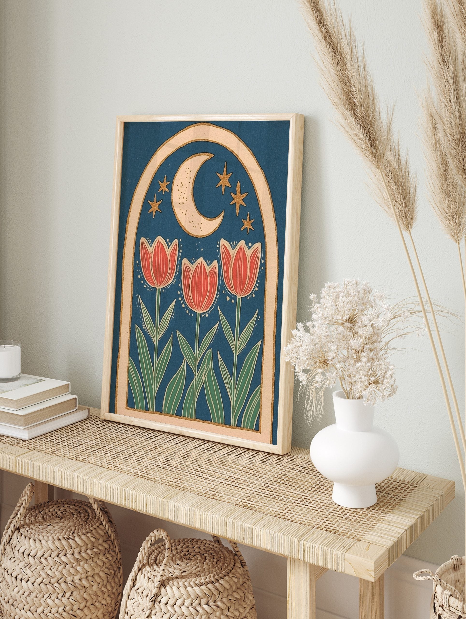 Illustrative folk art print with three red tulips, crescent moon, and golden stars within an, in an alternate framed mockup