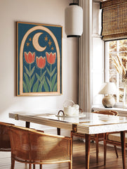 Illustrative folk art print with three red tulips, crescent moon, and golden stars within an arched, in a styled room mockup