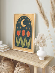Illustrative art print with three red tulips under a golden crescent moon and stars in a dark, in an alternate framed mockup