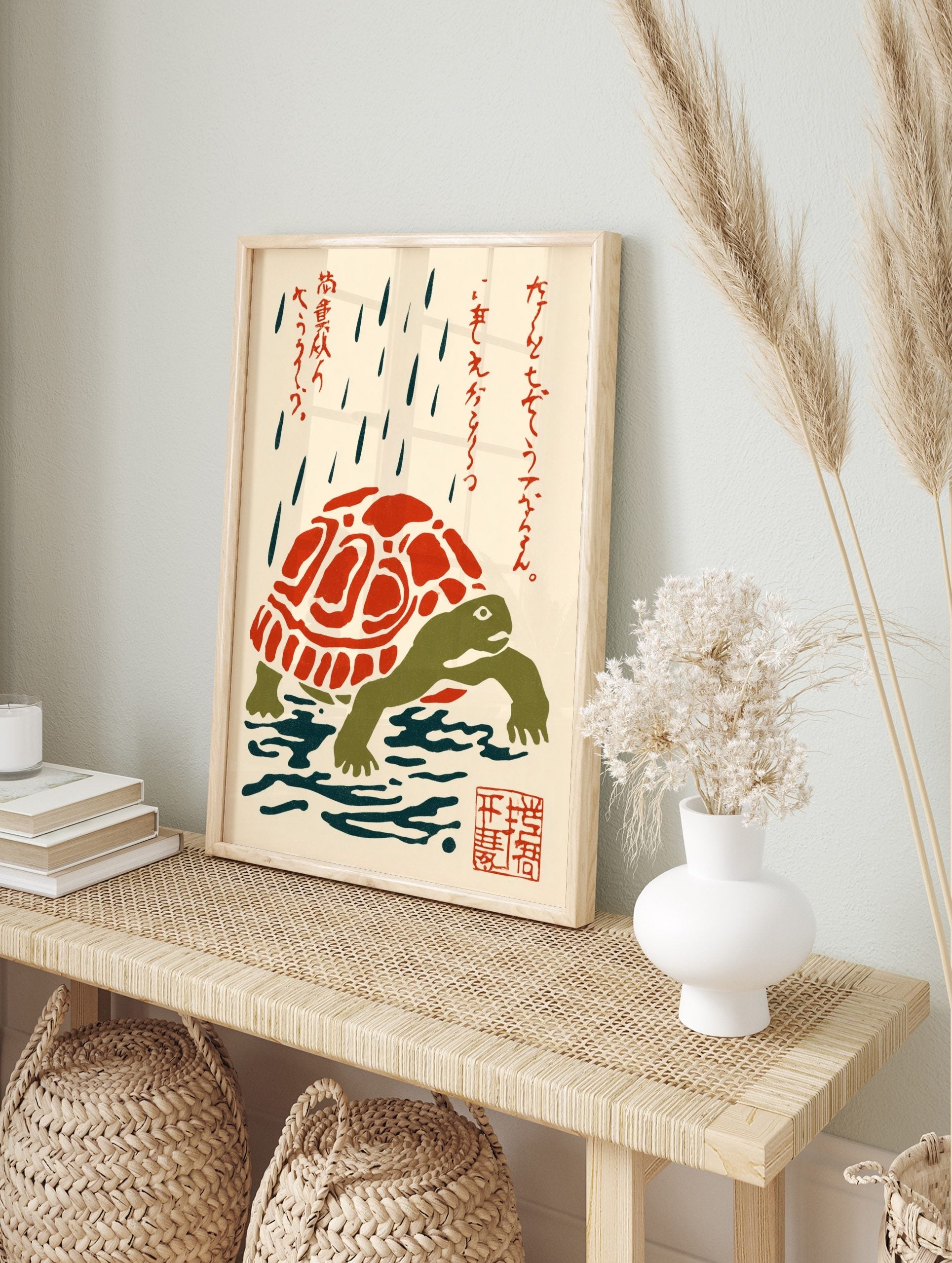 Japanese folk art print of a green turtle with a red and white shell in the rain, with red, in an alternate framed mockup