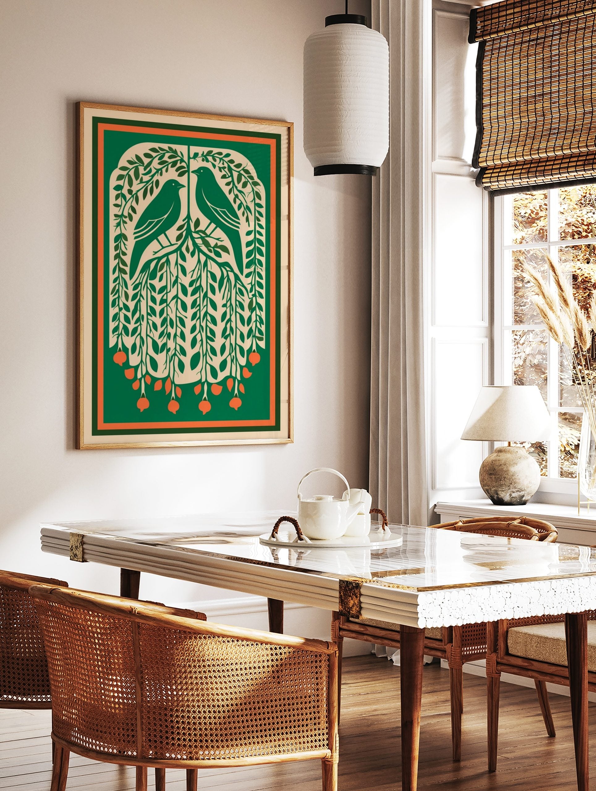 Illustrative green art print of two birds in a leafy tree with orange berries and a green-orange, in a styled room mockup