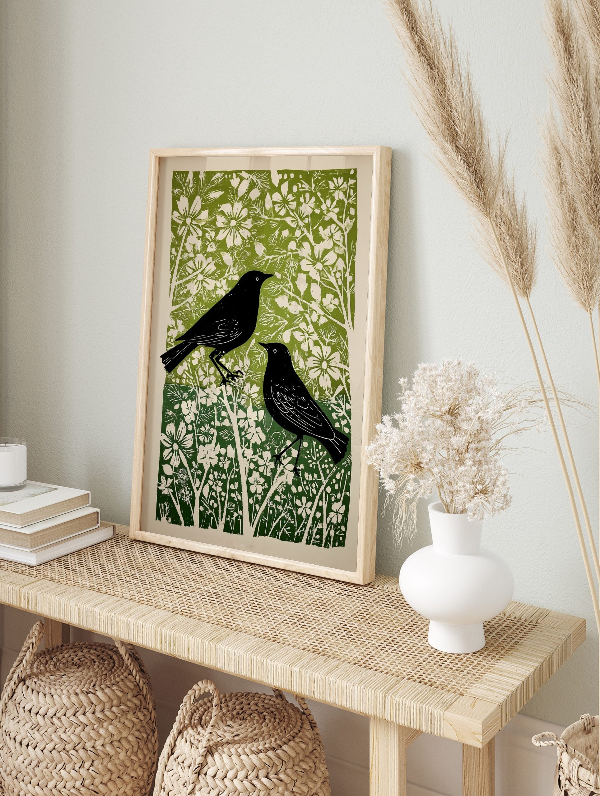Two black birds with white eyes in a green and white botanical linocut art print, portrait, in an alternate framed mockup