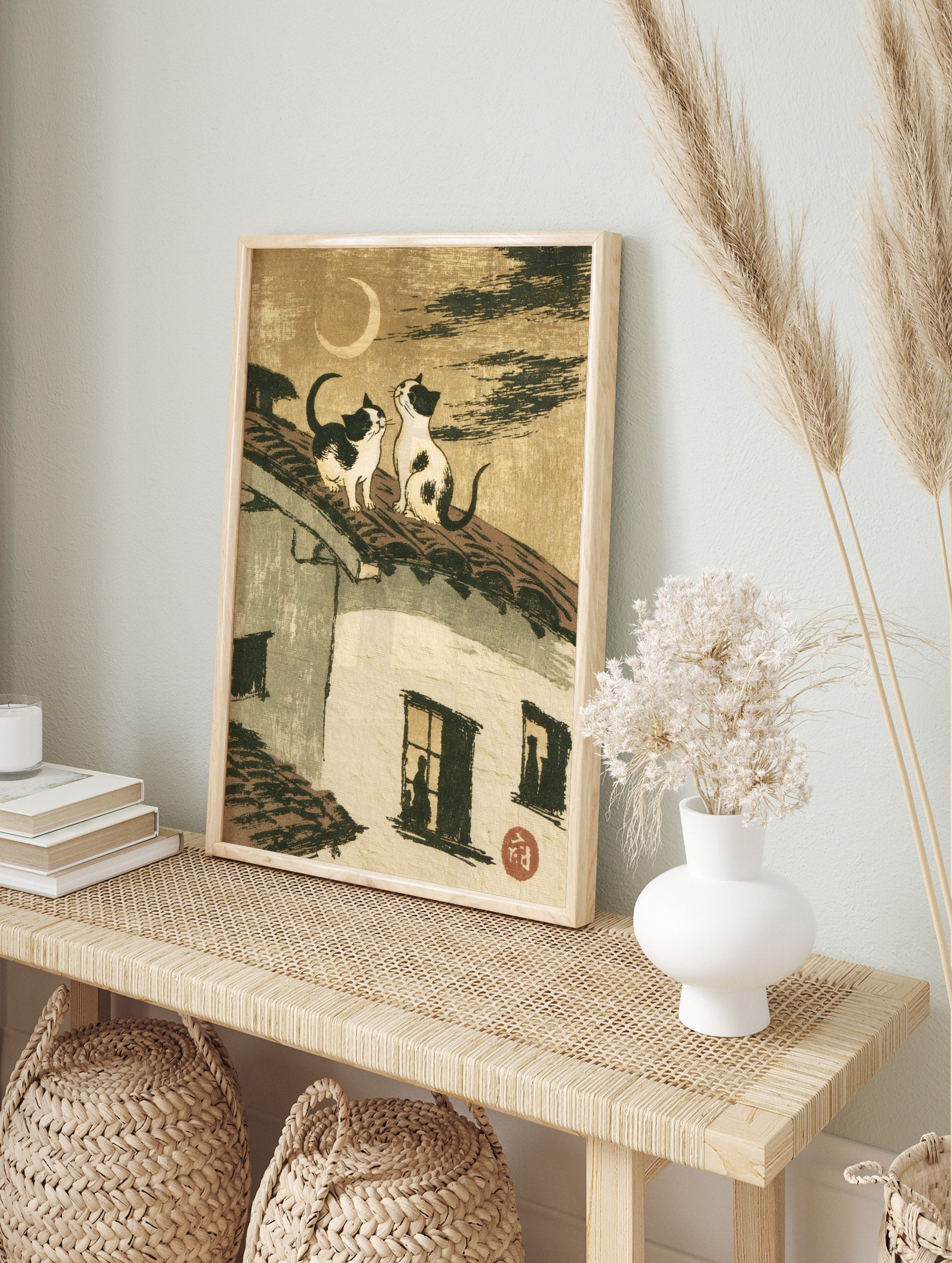 Two cats sitting on a tiled roof looking at a crescent moon, Japanese style illustration art, in an alternate framed mockup
