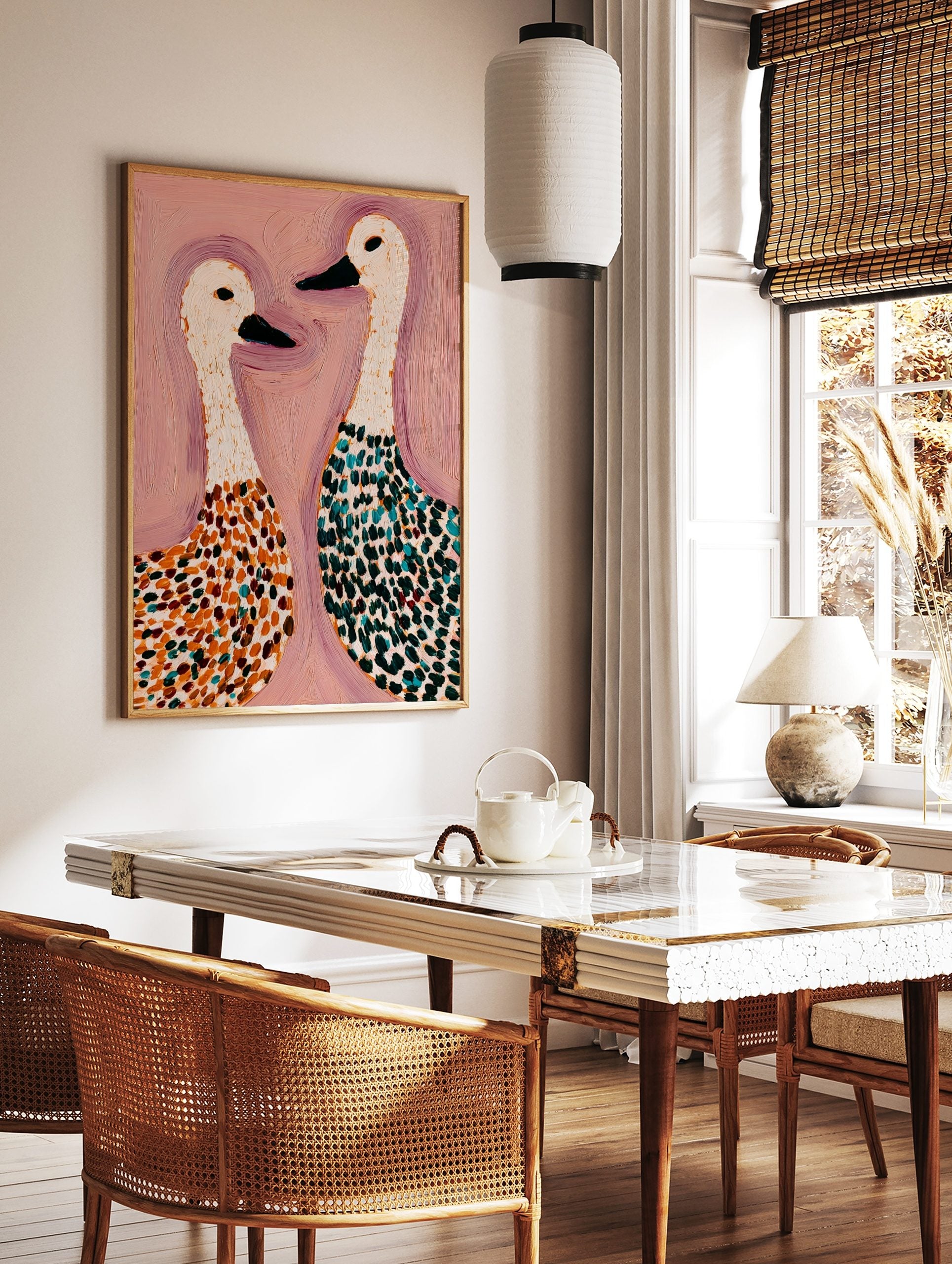 Abstract painting of two white geese with spotted bodies in orange, teal, and green on a pink, in a styled room mockup