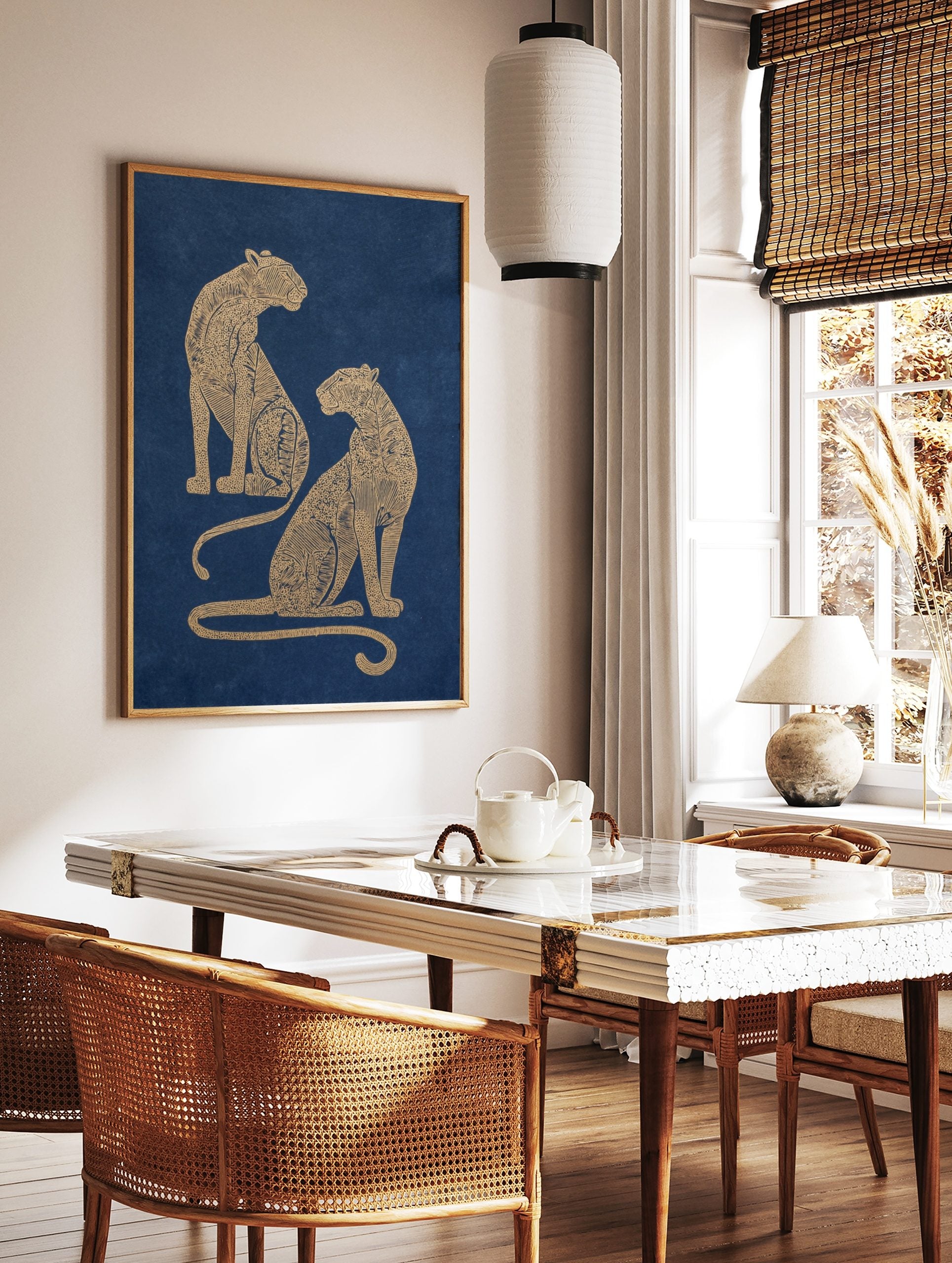 Two golden illustrative leopards with intricate patterns seated on a navy blue background, portrait, in a styled room mockup