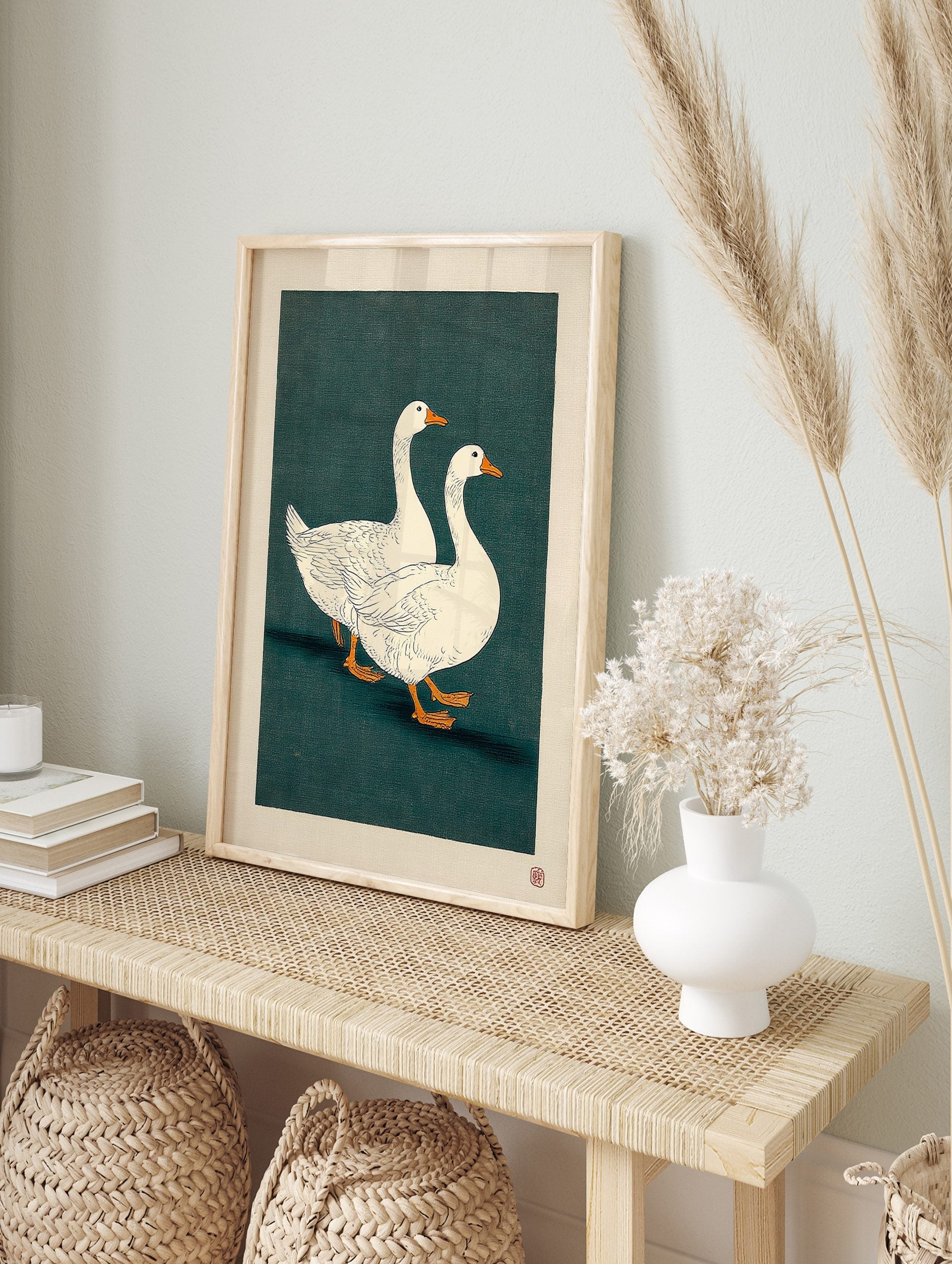 Two white geese with orange beaks walking on a dark teal background in a Japanese, in an alternate framed mockup