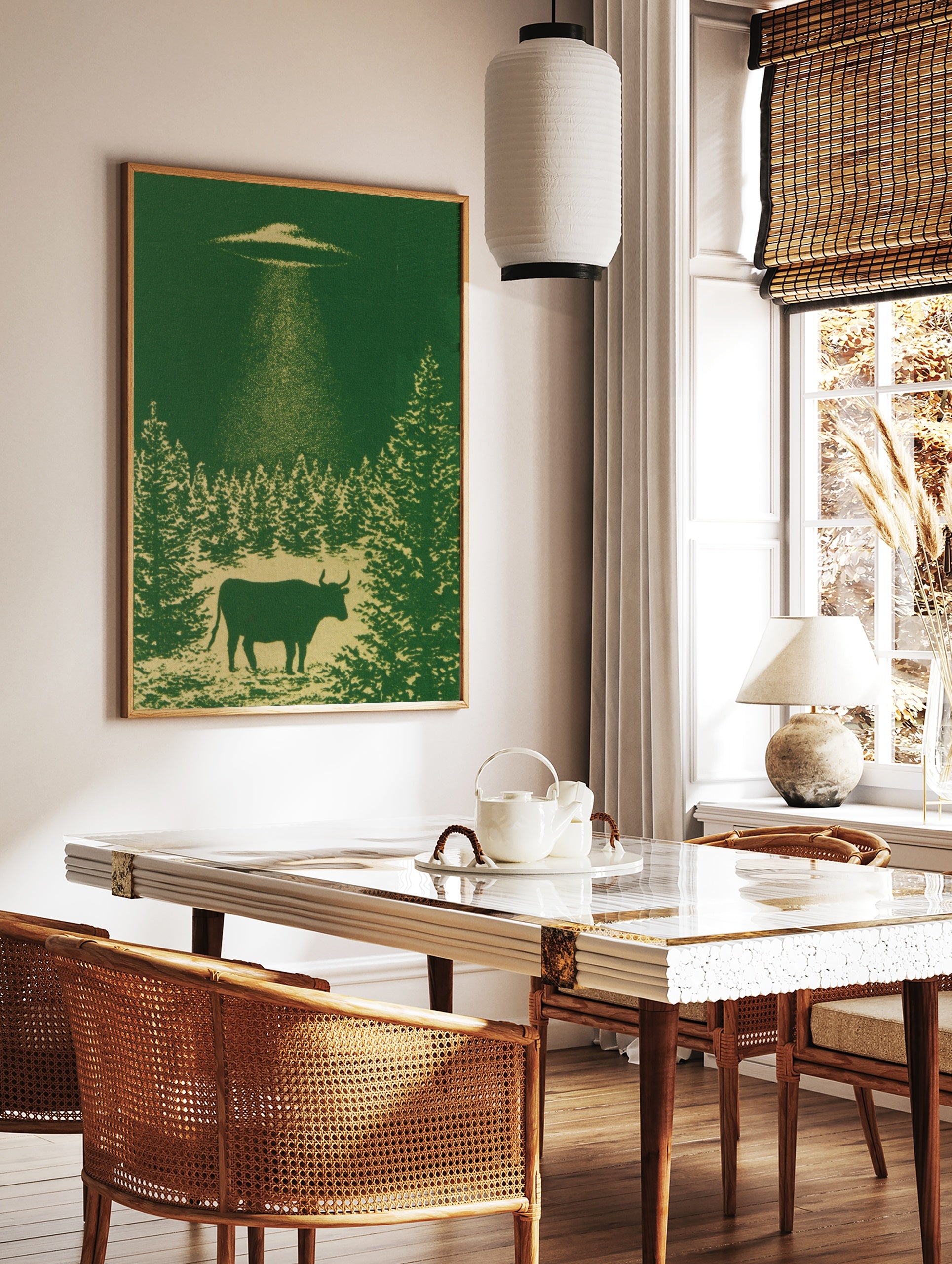 Monochromatic green wall art print of a cow being abducted by a UFO above a forest silhouette, in a styled room mockup