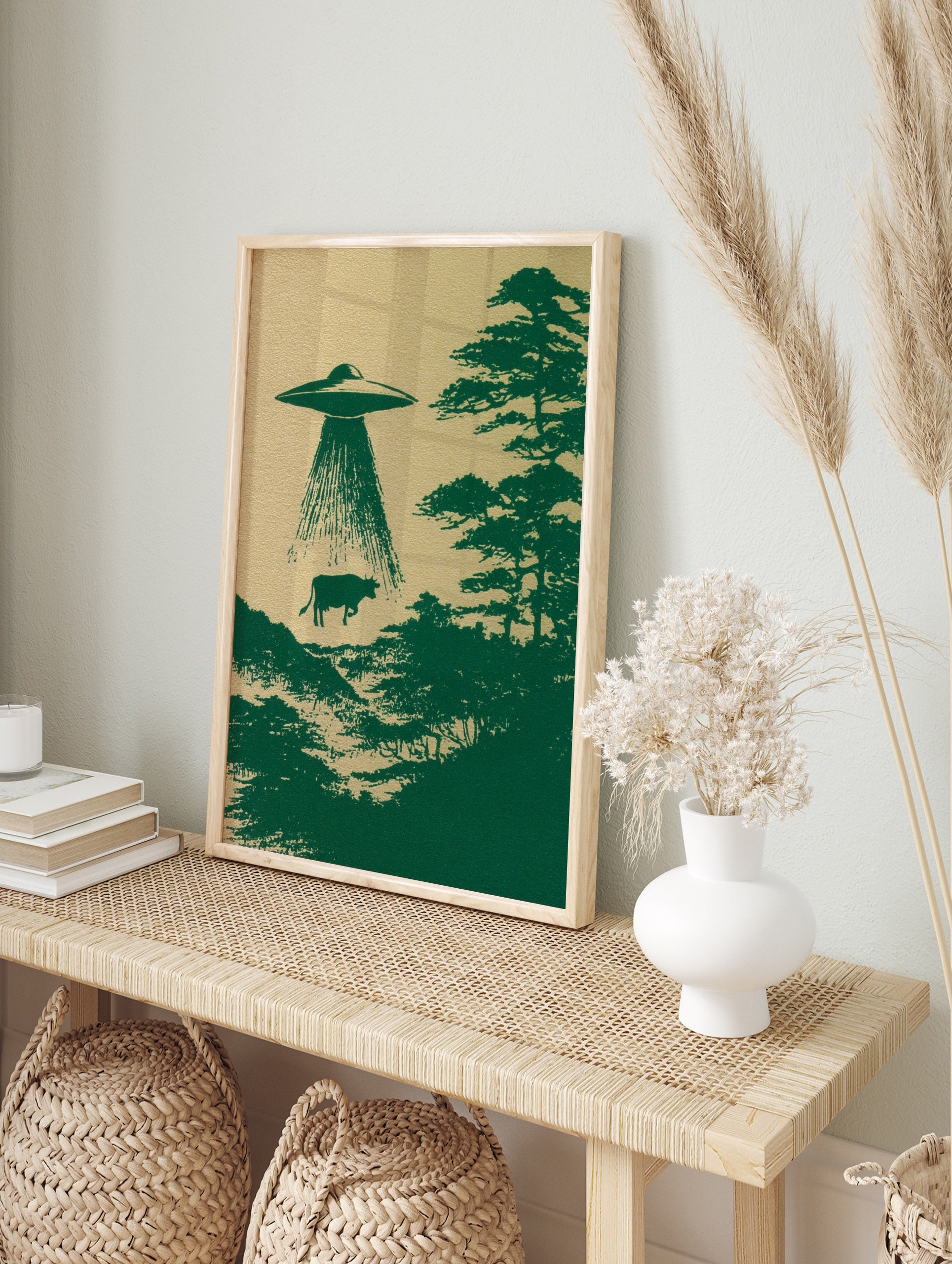 UFO abducting a cow in an illustrative green print on textured background, in an alternate framed mockup