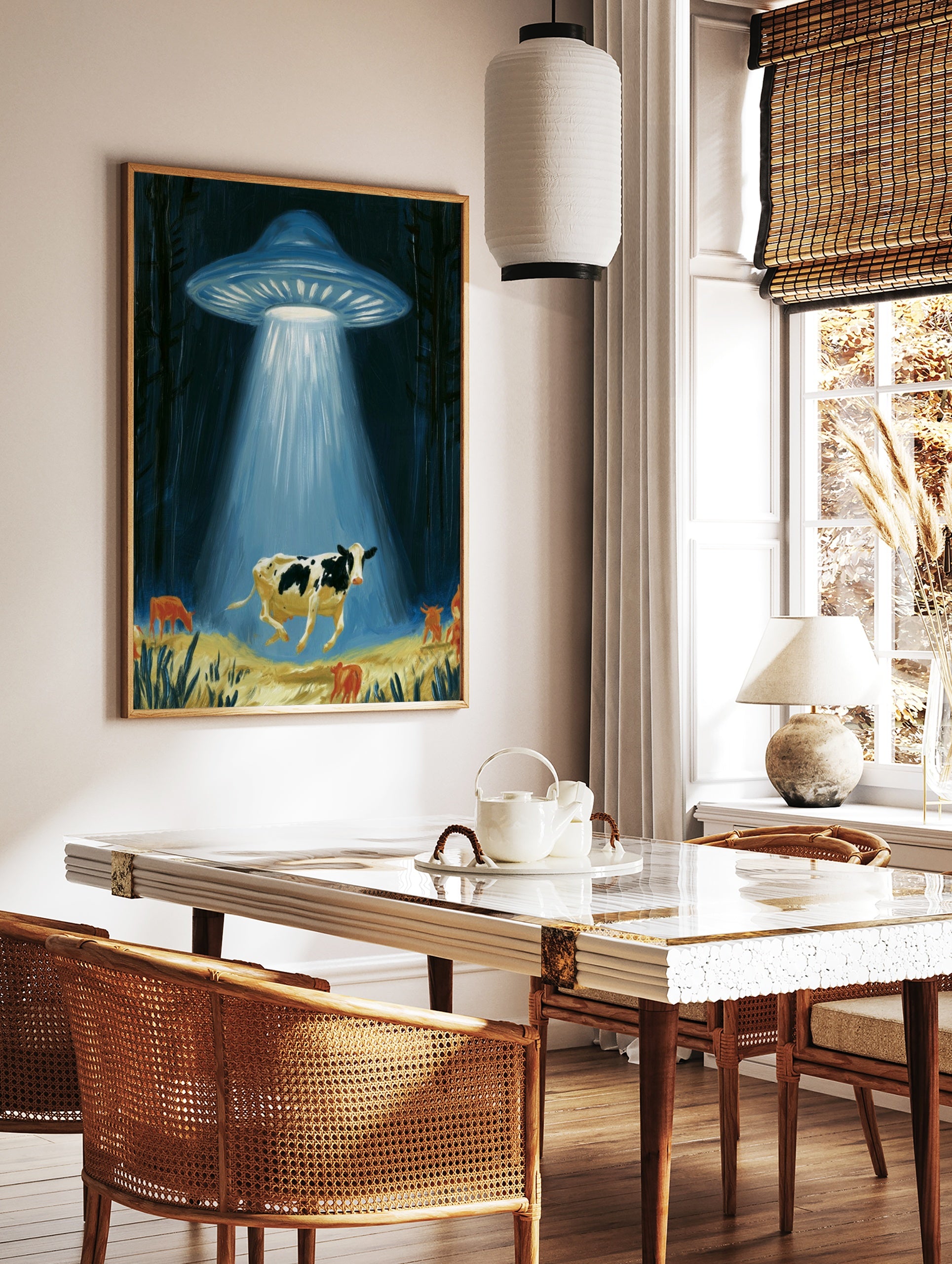 Surreal illustrative art print of a UFO abducting a cow with a glowing light beam in a dark forest, in a styled room mockup