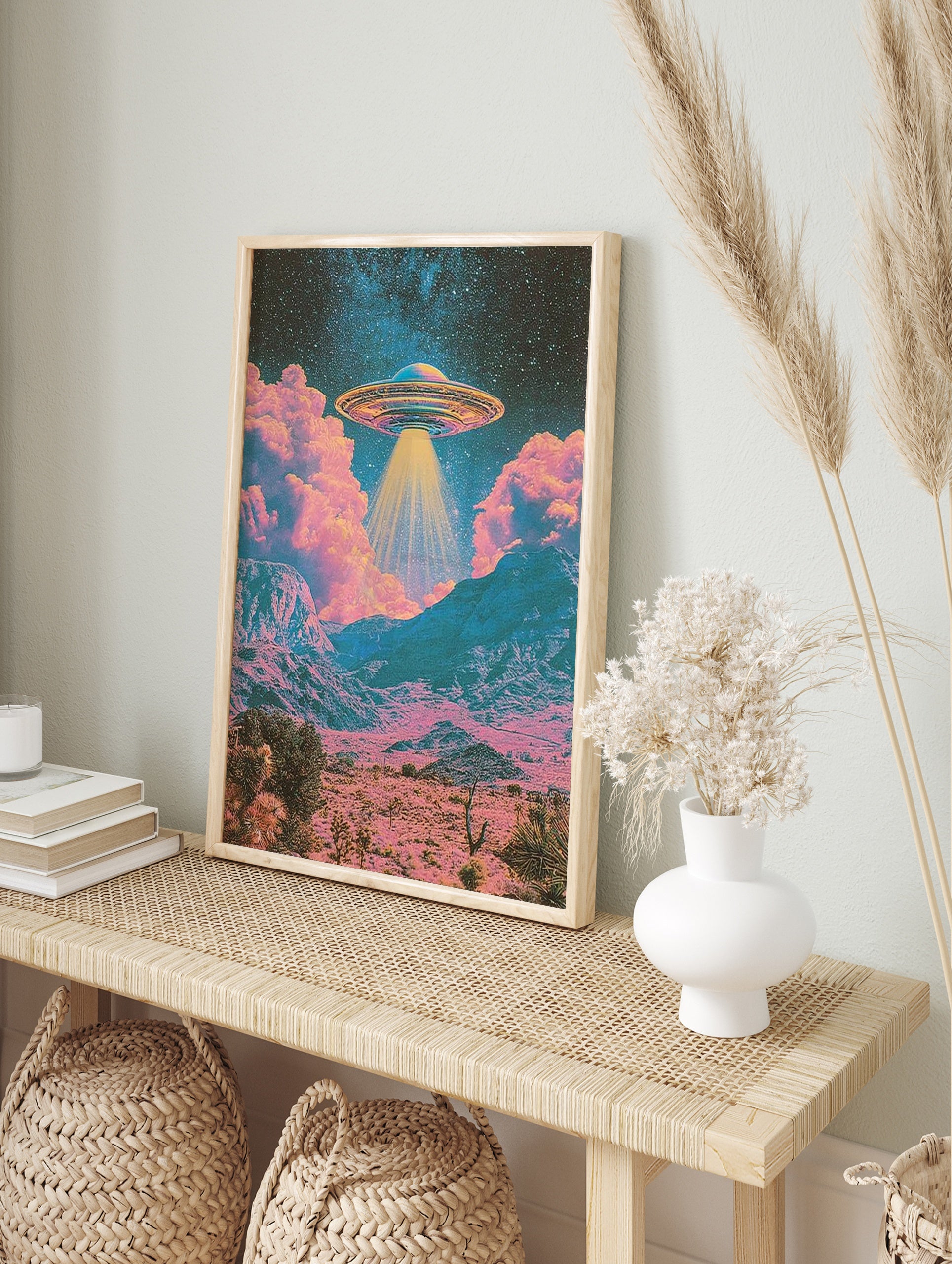 Retro sci-fi UFO hovering above a pink and teal desert landscape with stars in the night sky, in an alternate framed mockup