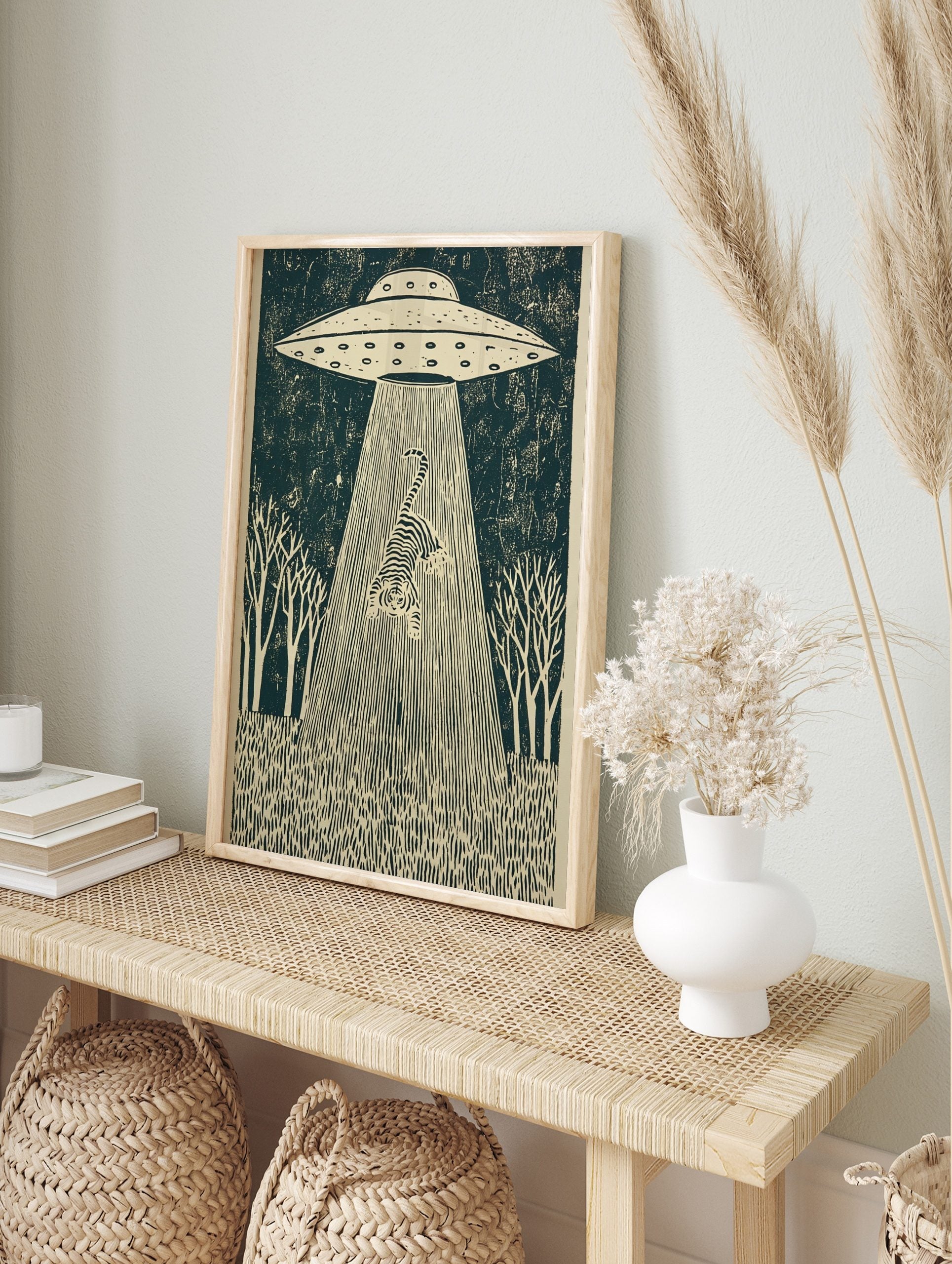 UFO abducting a striped tiger in a dark forest scene, illustrative linocut style wall art, in an alternate framed mockup