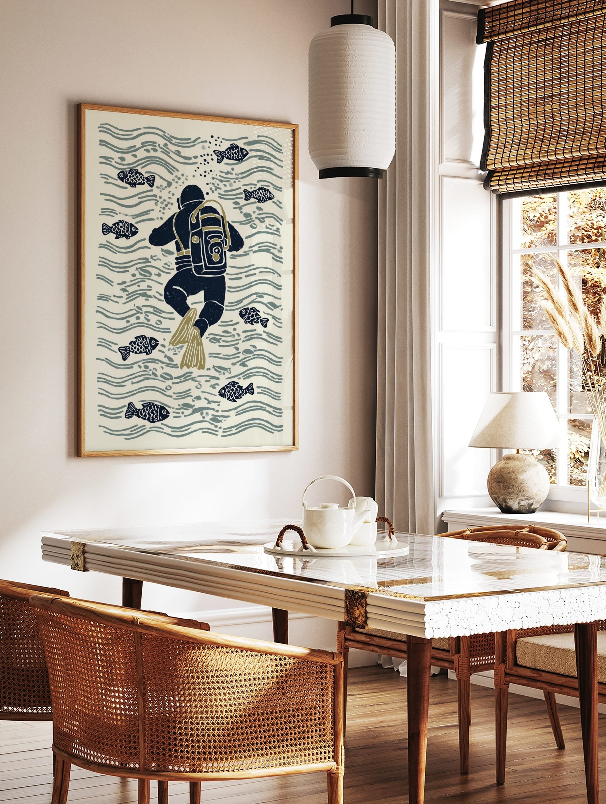 Illustrative print of a navy blue scuba diver with olive flippers swimming among fish and water, in a styled room mockup