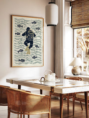 Illustrative print of a navy blue scuba diver with olive flippers swimming among fish and water, in a styled room mockup