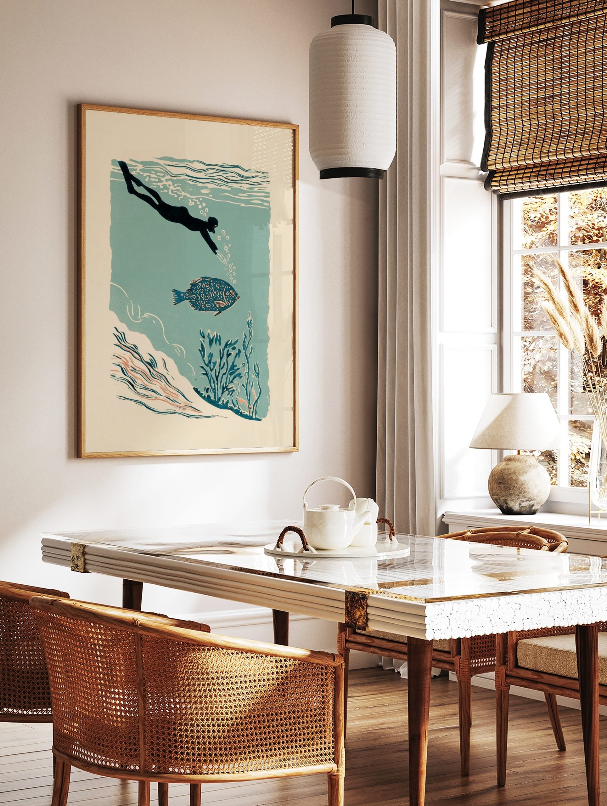 Illustrative print of a diver swimming with a patterned blue fish in teal water with underwater, in a styled room mockup