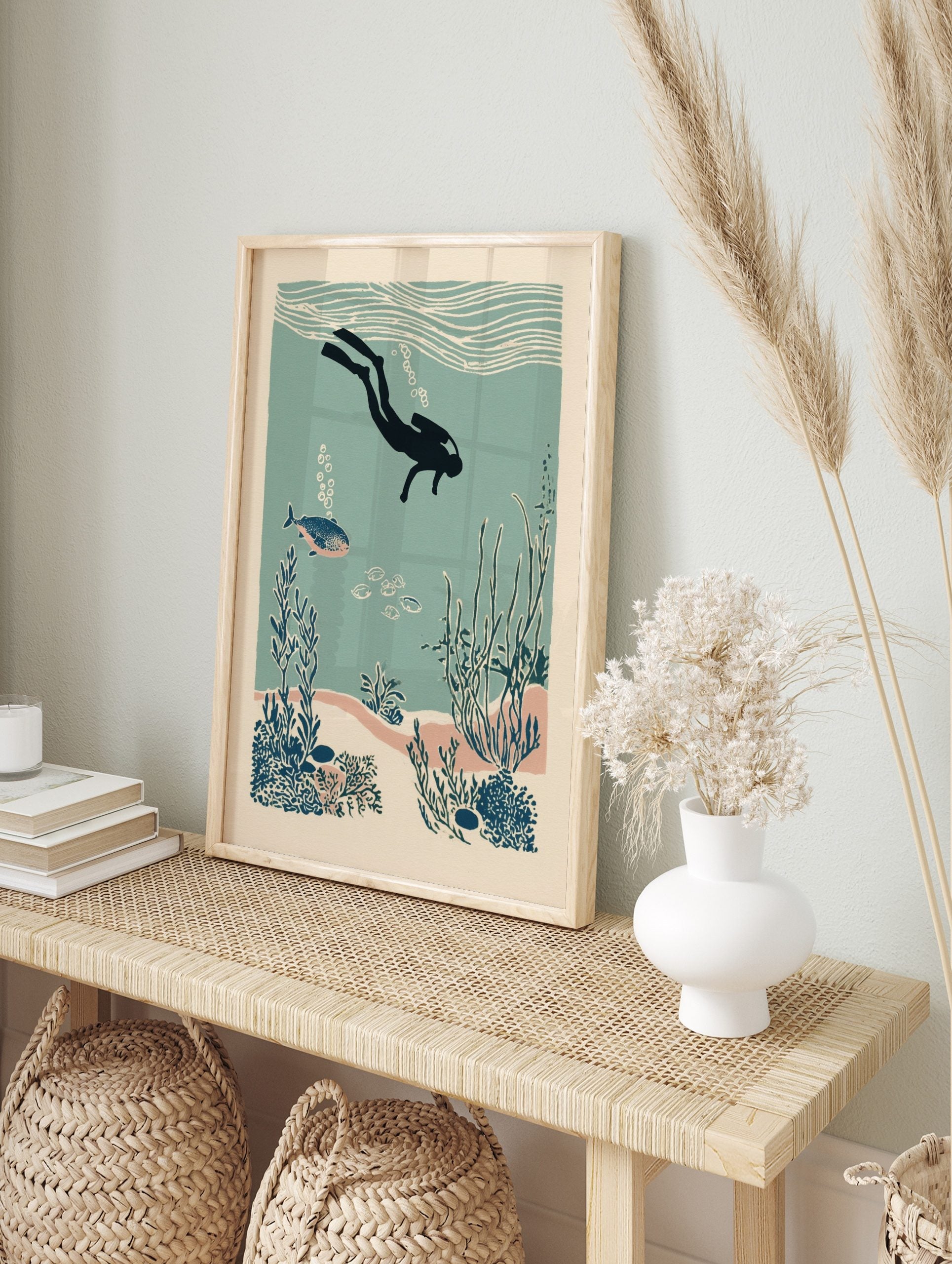 Illustrative scuba diver exploring an underwater coral reef with fish and seaweed in teal and, in an alternate framed mockup