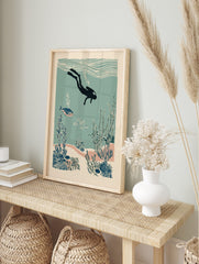 Illustrative scuba diver exploring an underwater coral reef with fish and seaweed in teal and, in an alternate framed mockup