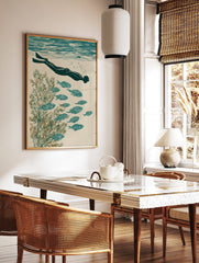 Illustrative print of an underwater swimmer with fins, school of fish, and green seaweed in teal, in a styled room mockup