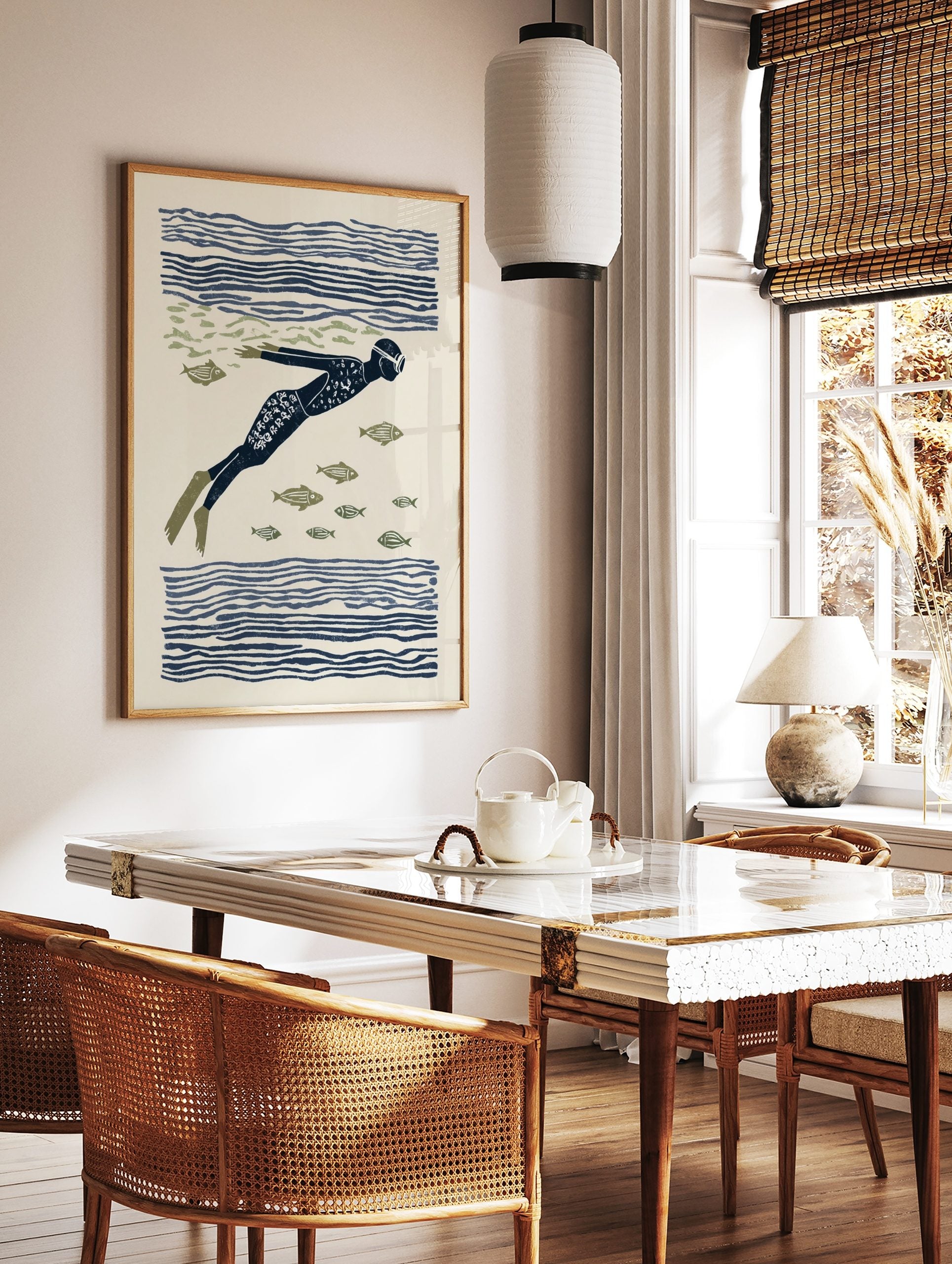 Illustrative print of an underwater swimmer in a dark blue suit and flippers, surrounded by olive, in a styled room mockup