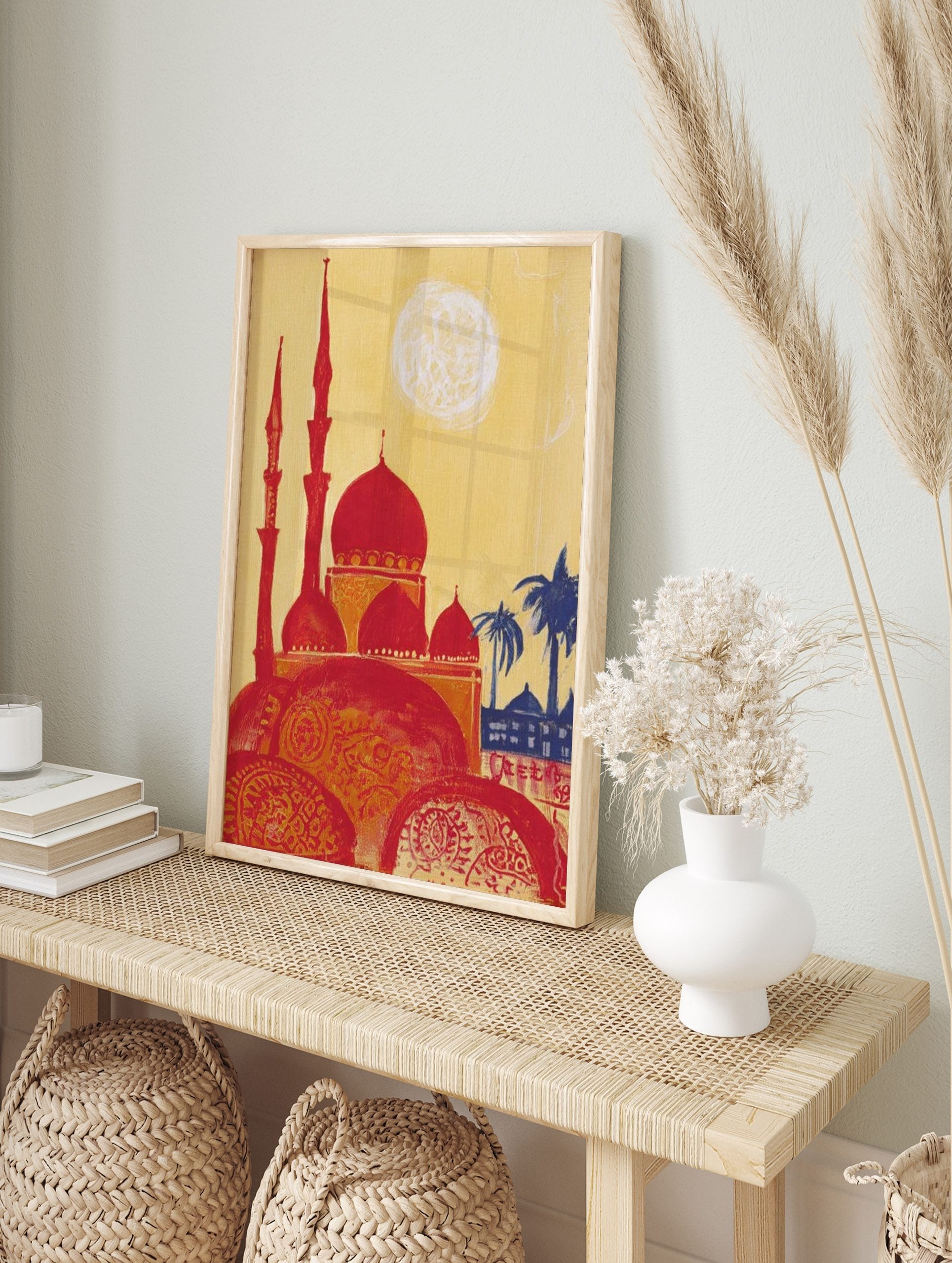Illustrative print of a red mosque with multiple domes and minarets, yellow sky, blue palm, in an alternate framed mockup