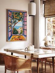 Vibrant orange tree poster with a coastal view of the sea and town through a window, featuring a still life of oranges. - Image 2