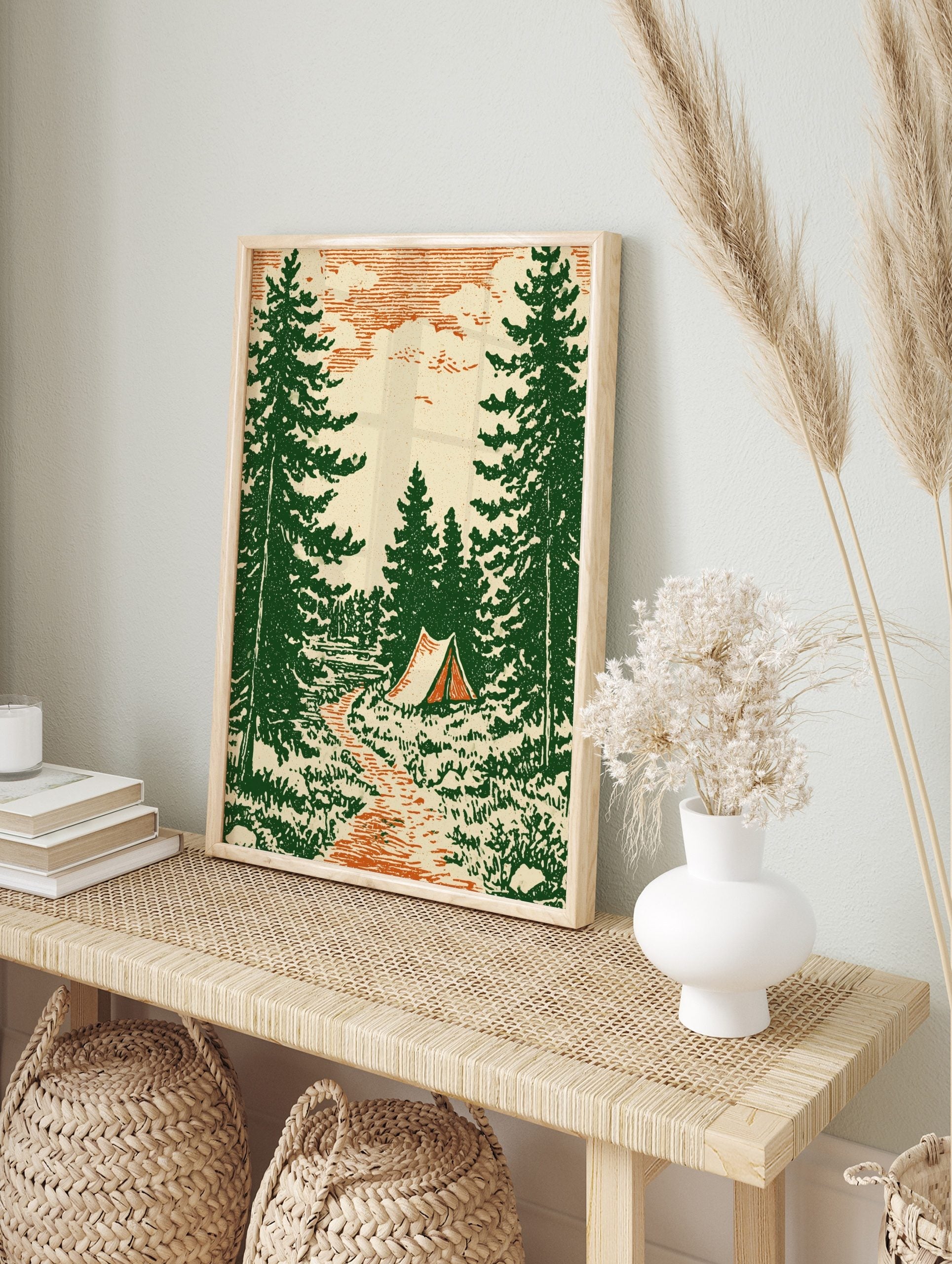 Vintage illustrative camping scene with green pine trees, orange path, and a tent under a, in an alternate framed mockup