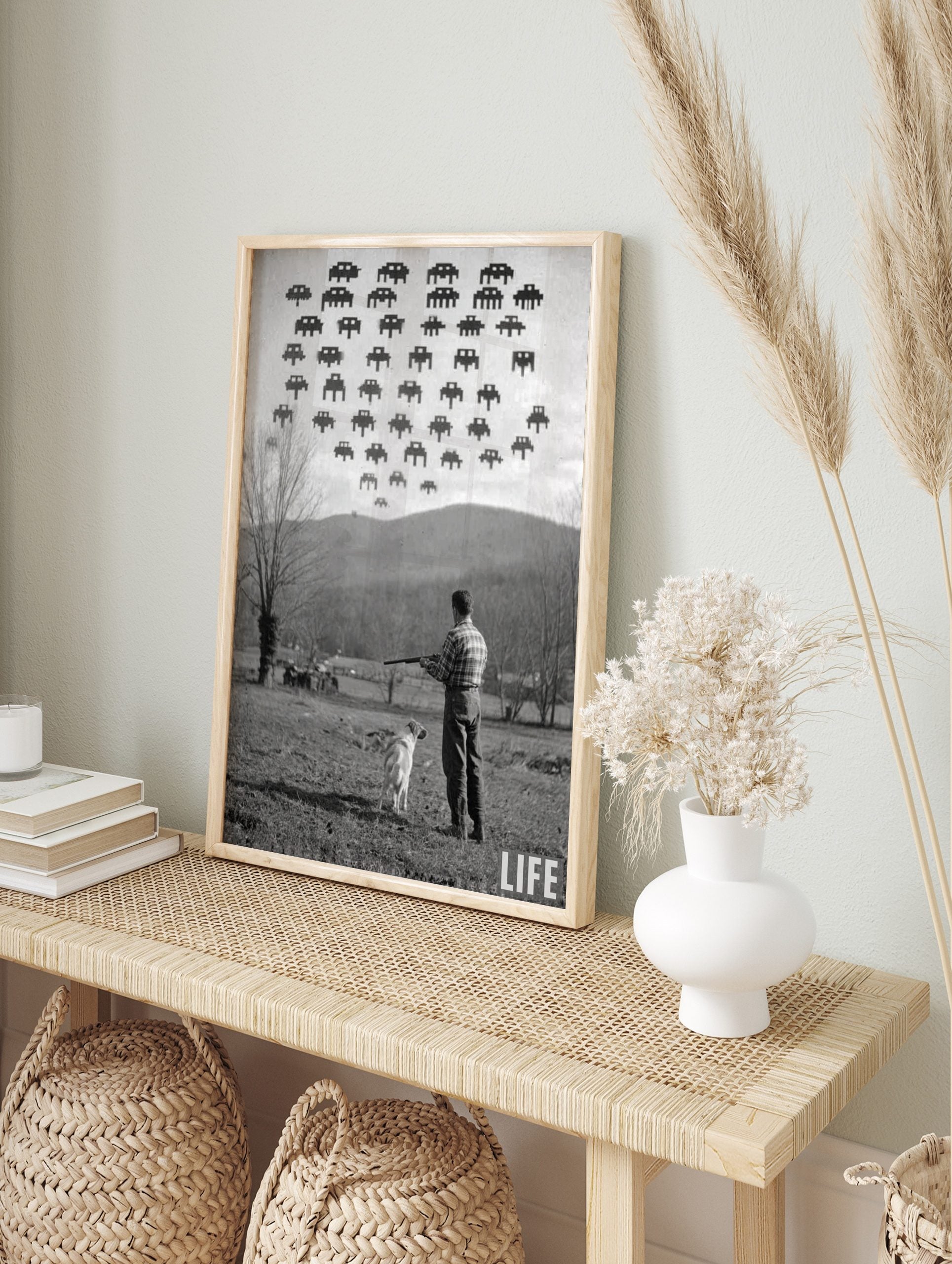 Monochrome photographic print of a man and dog looking up at pixelated Space Invaders in the, in an alternate framed mockup