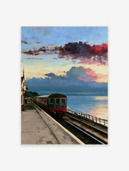 Vintage train carriage at a coastal railway station under a dramatic red and blue sunset sky